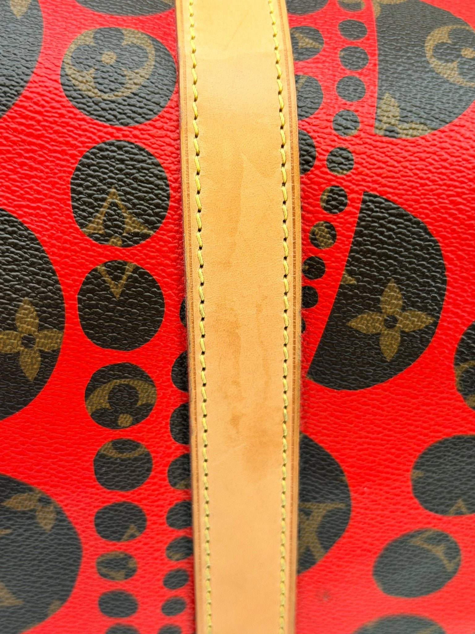 Louis Vuitton x Yayoi Kusama polka dot travel bag with vibrant black and white pattern and gold hardware by Gold & Beyond.