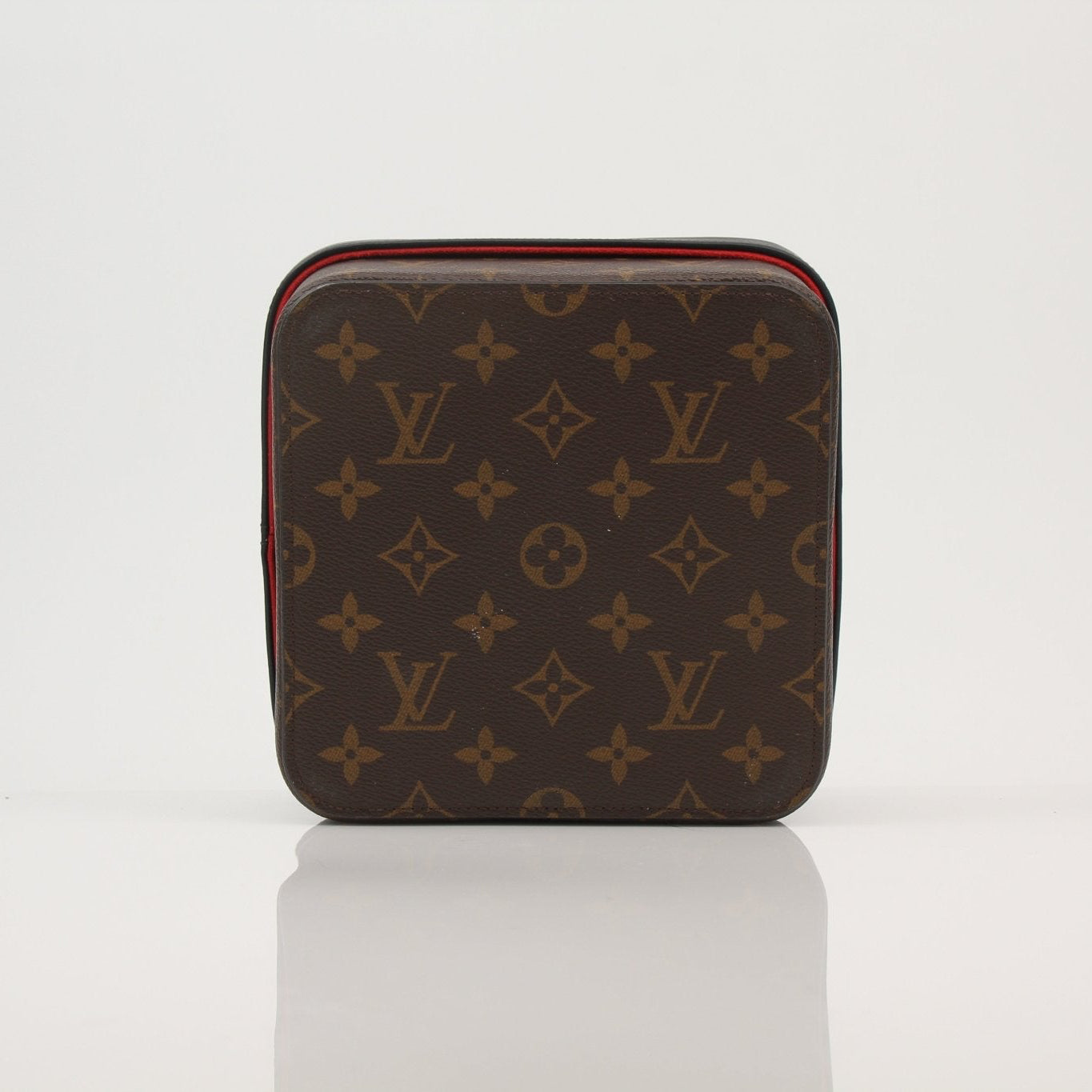 Louis Vuitton Camille Box accessory in gold with black detailing, classic Louis Vuitton design, on a neutral background.