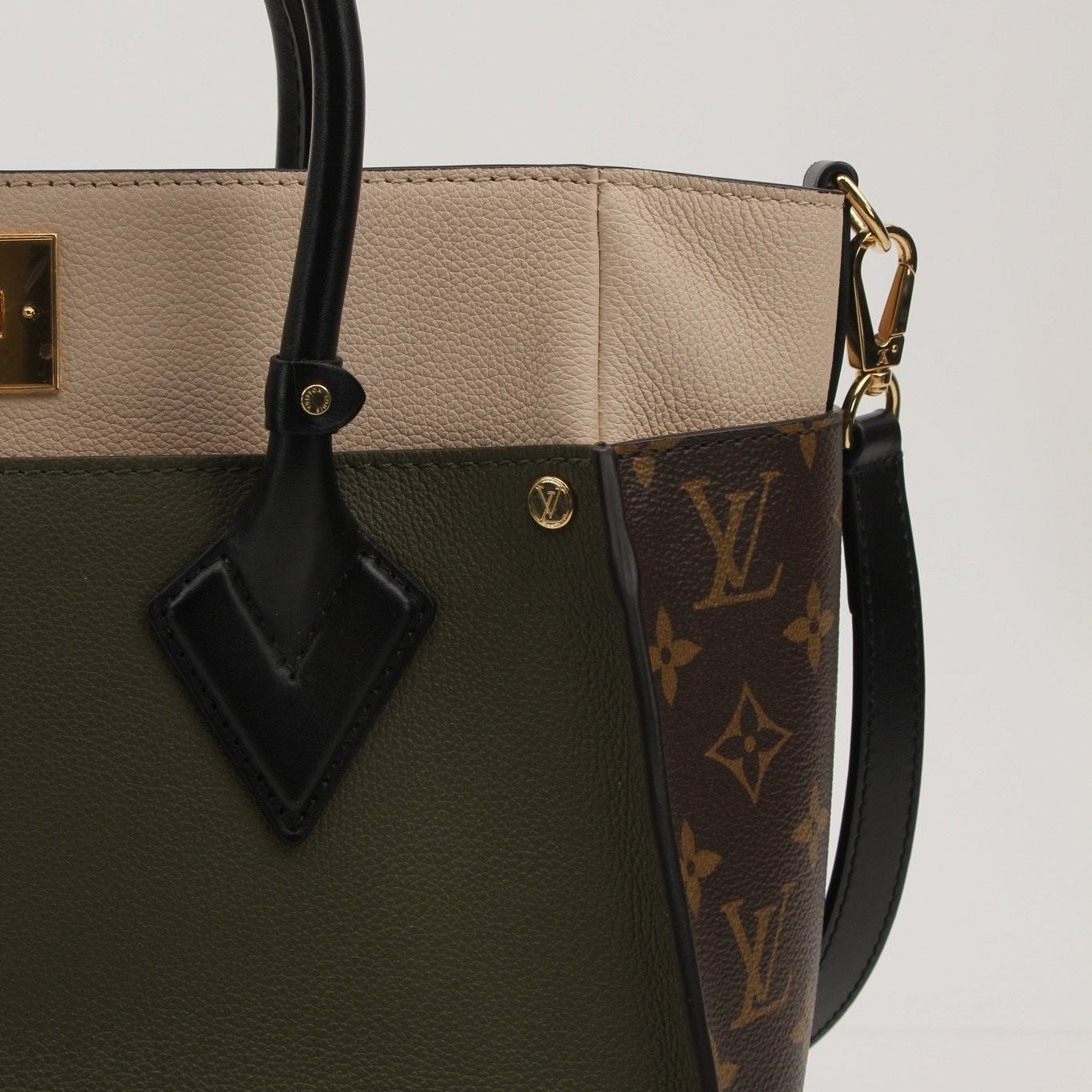 Louis Vuitton On My Side MM handbag in tan leather with gold hardware, featuring a structured design and top handles.