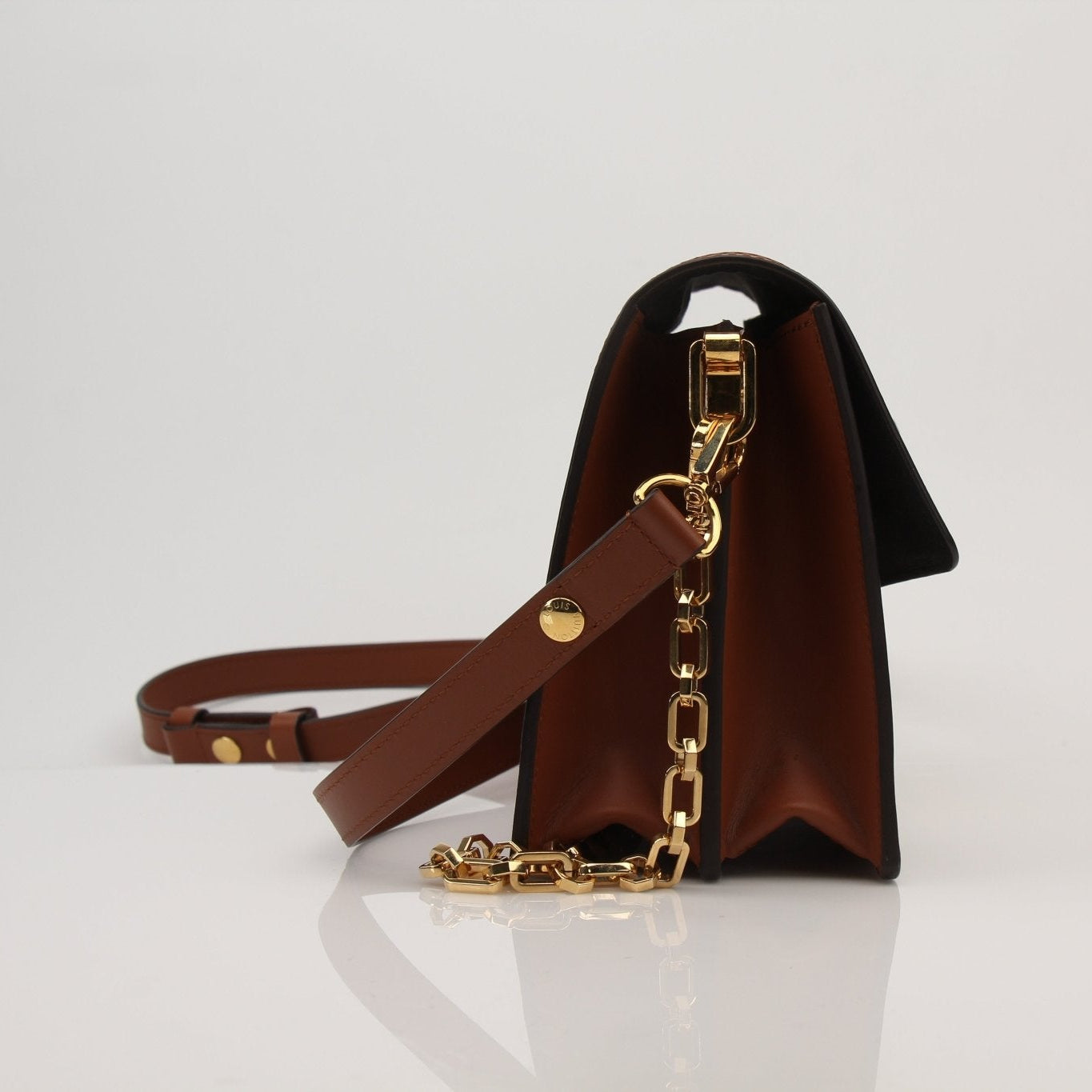 Louis Vuitton Dauphine MM handbag in brown leather with gold hardware, featuring a structured design and top handle.