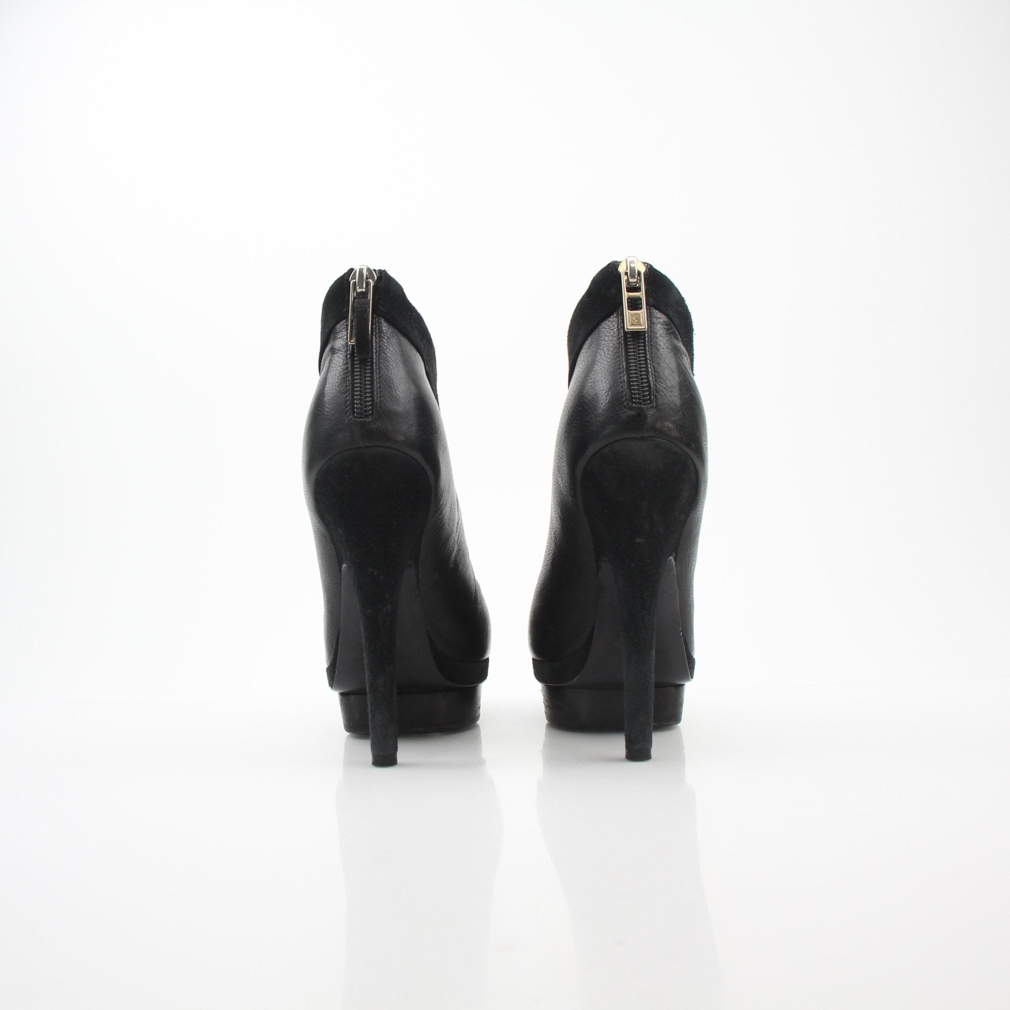 Black leather Saint Laurent Rive Gauche ankle platform pumps with high heels, featuring a sleek design and pointed toes.