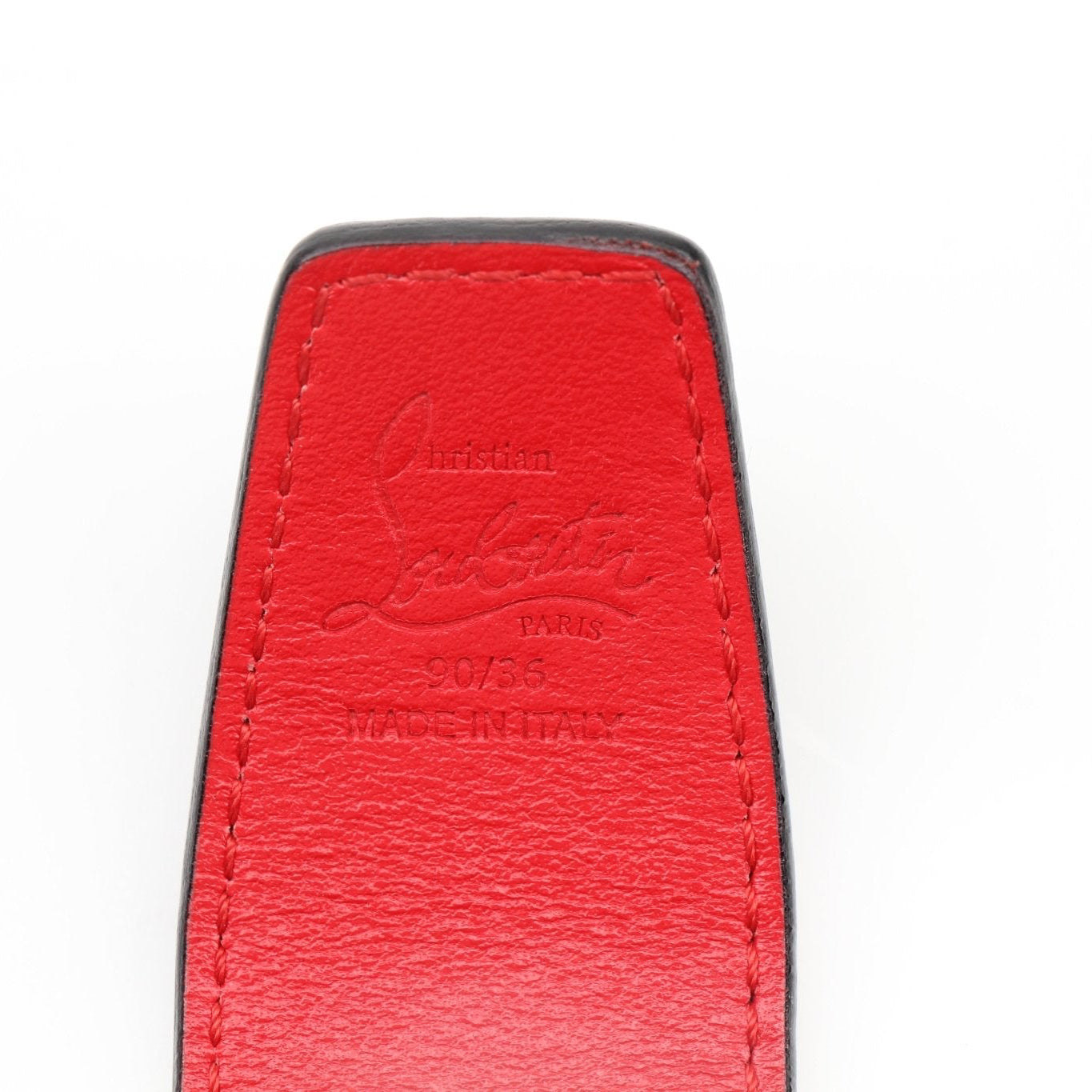 Christian Louboutin croc-embossed leather belt featuring gold-tone hardware, styled with accessories.