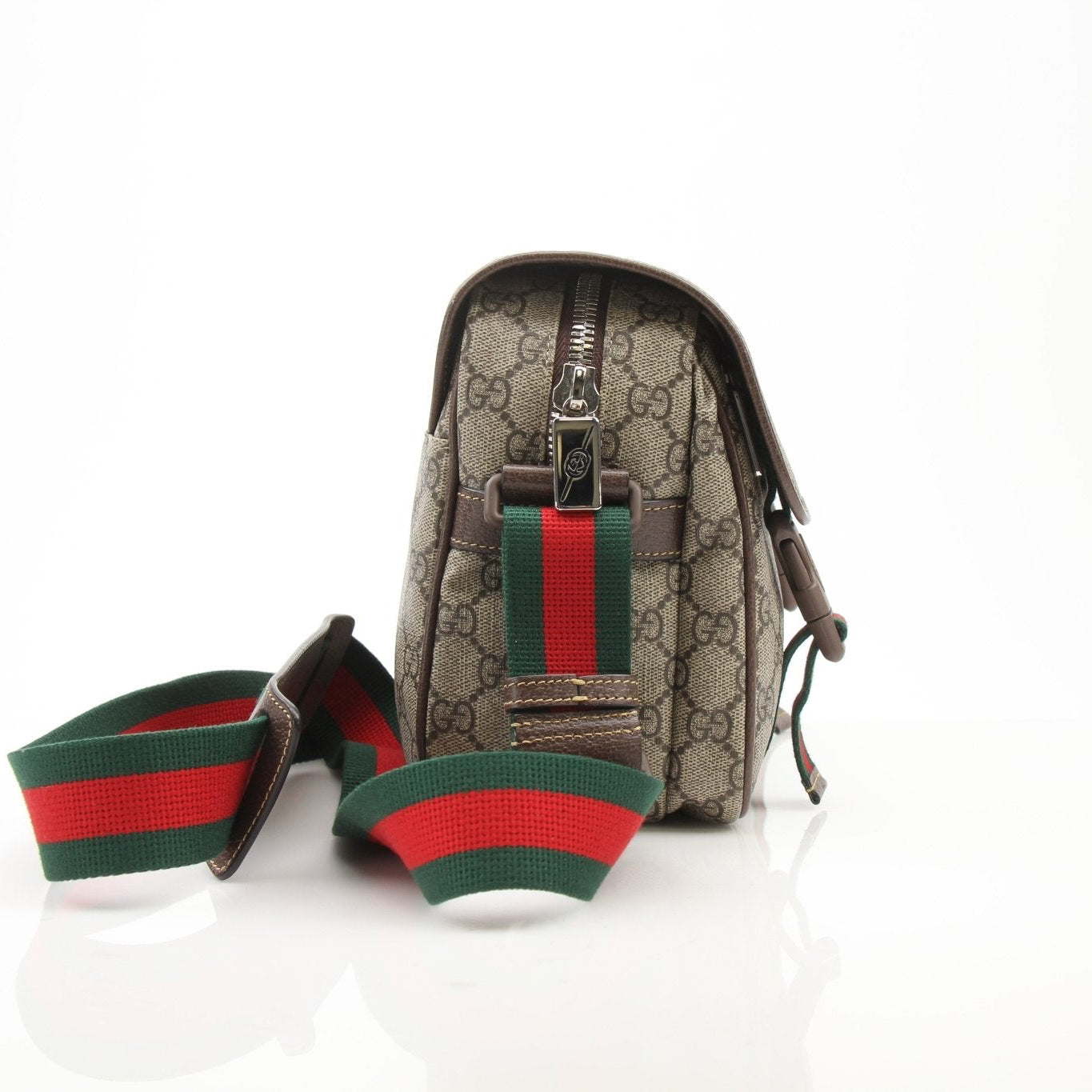 Gold & Beyond Gucci GG Supreme handbag with adjustable strap and logo pattern, displayed on a plain background.