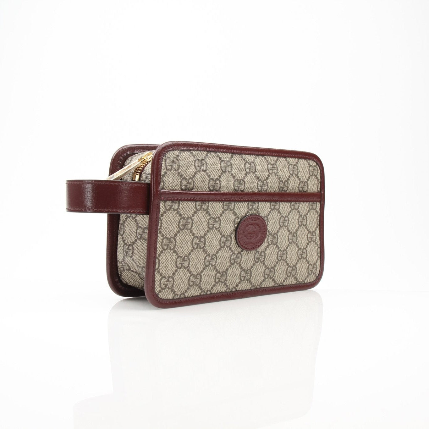 Gucci GG Supreme Dopp Kit pouch for travel, featuring signature monogram design and gold-tone hardware.