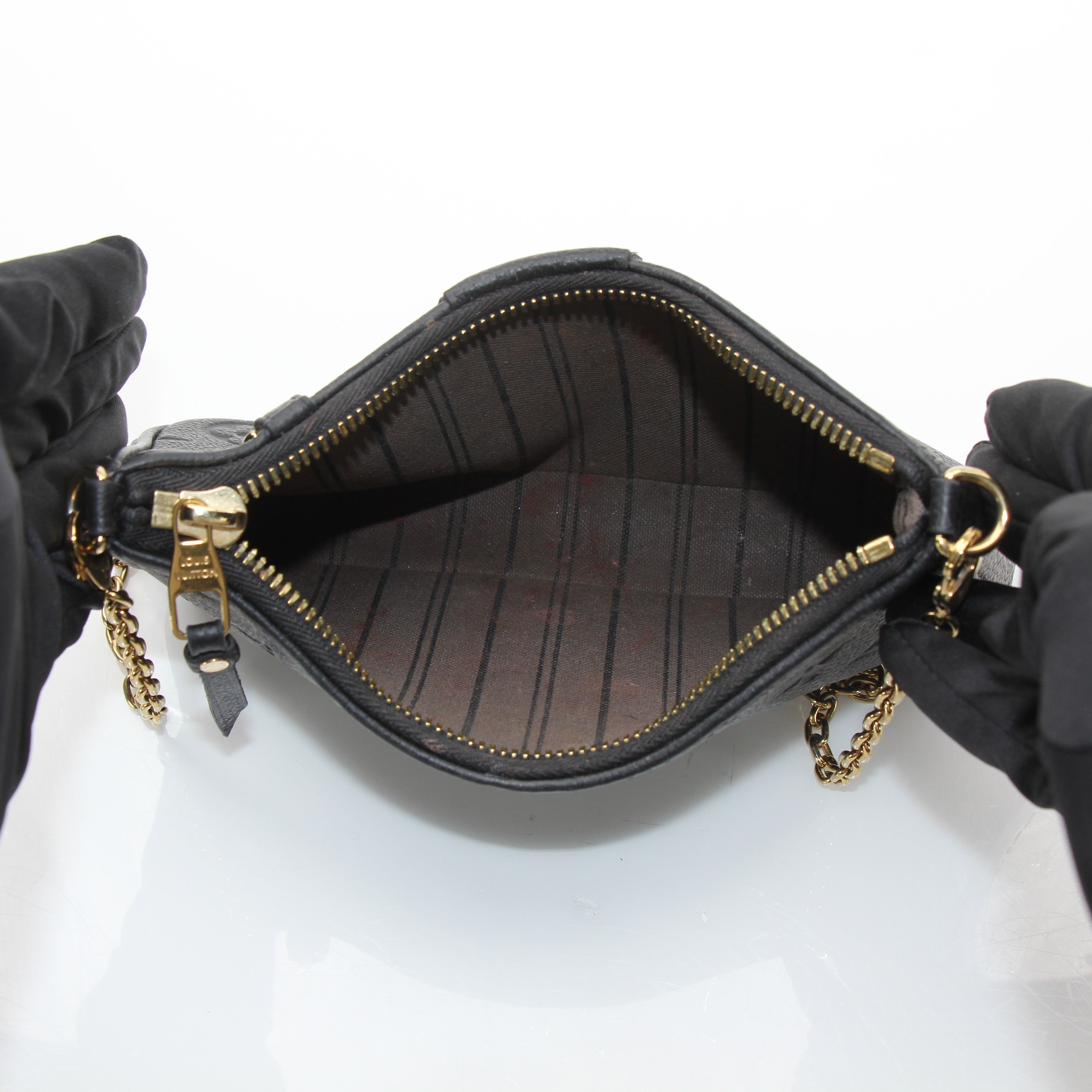 Louis Vuitton black Easy Pouch handbag on strap with gold accents, stylish accessory with sleek design and compact size.