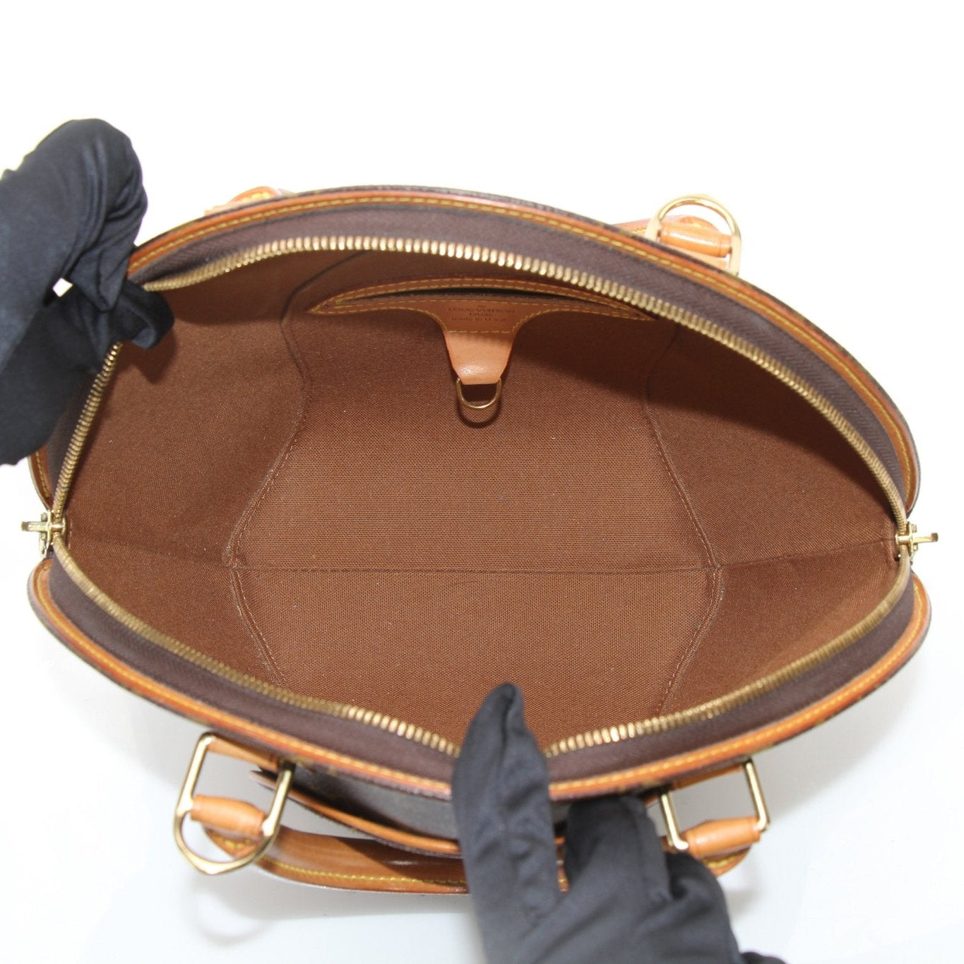 Louis Vuitton Ellipse PM top handle handbag with gold hardware and structured design, showcased in a natural setting.