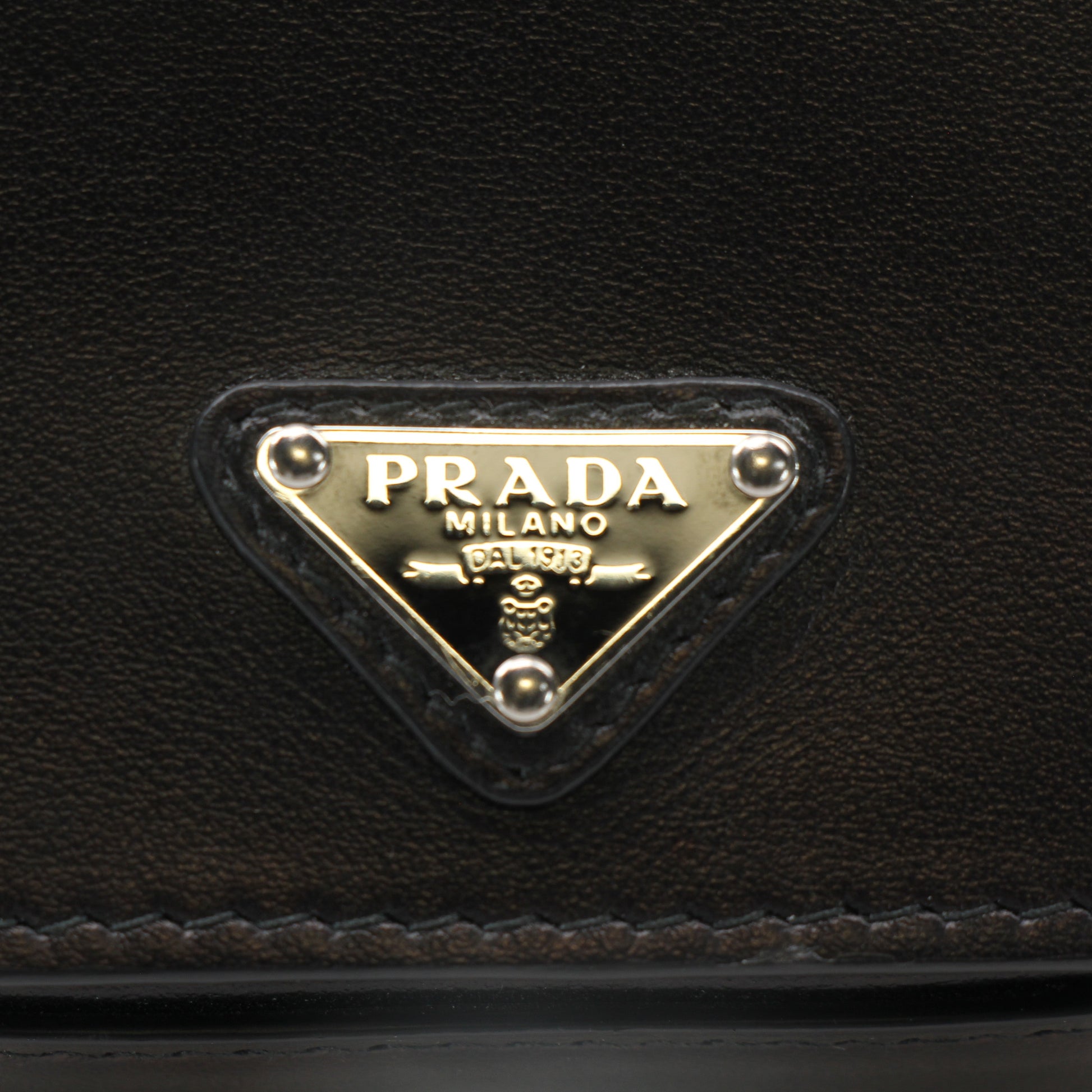 Prada black logo plaque belt bag with wallet design, featuring sleek leather and gold hardware accents.