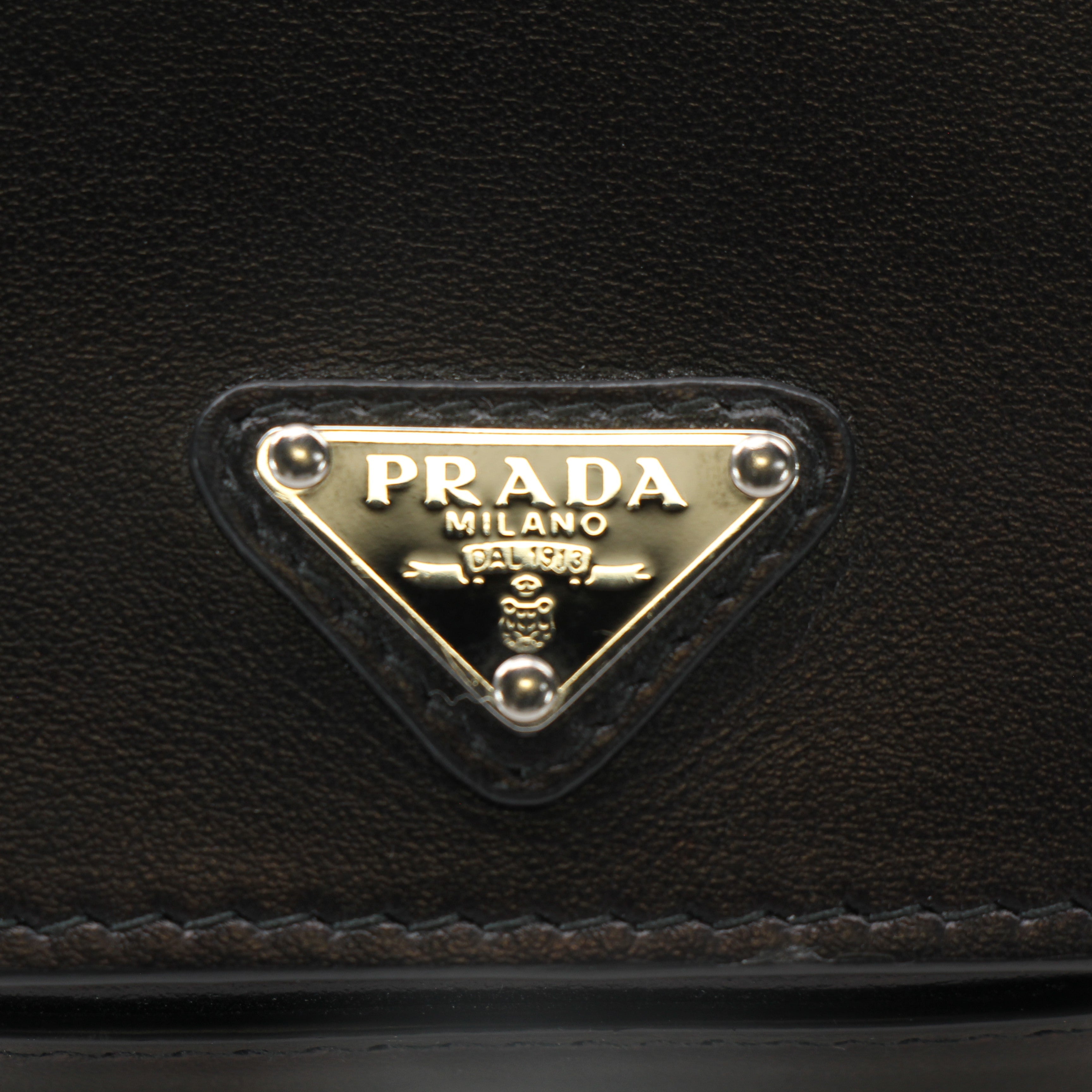 Prada black logo plaque belt bag with wallet design, featuring sleek leather and gold hardware accents.