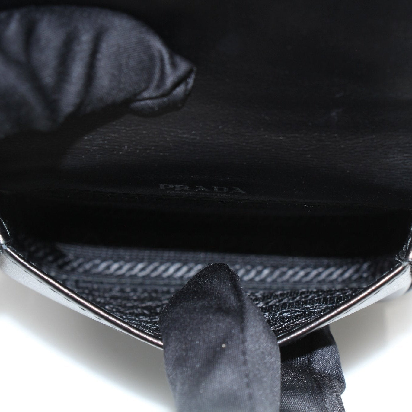 Prada black logo plaque belt bag showing the front view with adjustable strap and signature Prada logo detail.