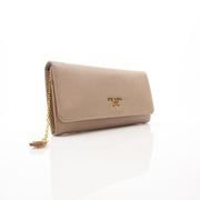 Beige Prada Saffiano Lux Continental Flap Wallet with gold-tone hardware and textured leather, displayed on a white background.