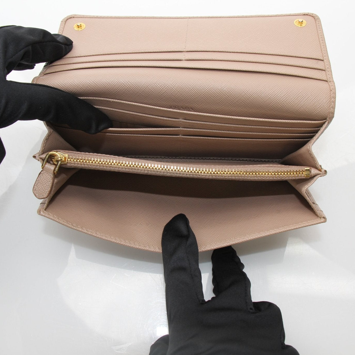 Beige Prada Saffiano Lux continental flap wallet with gold-tone hardware, featuring a sleek leather design and gold logo detail.