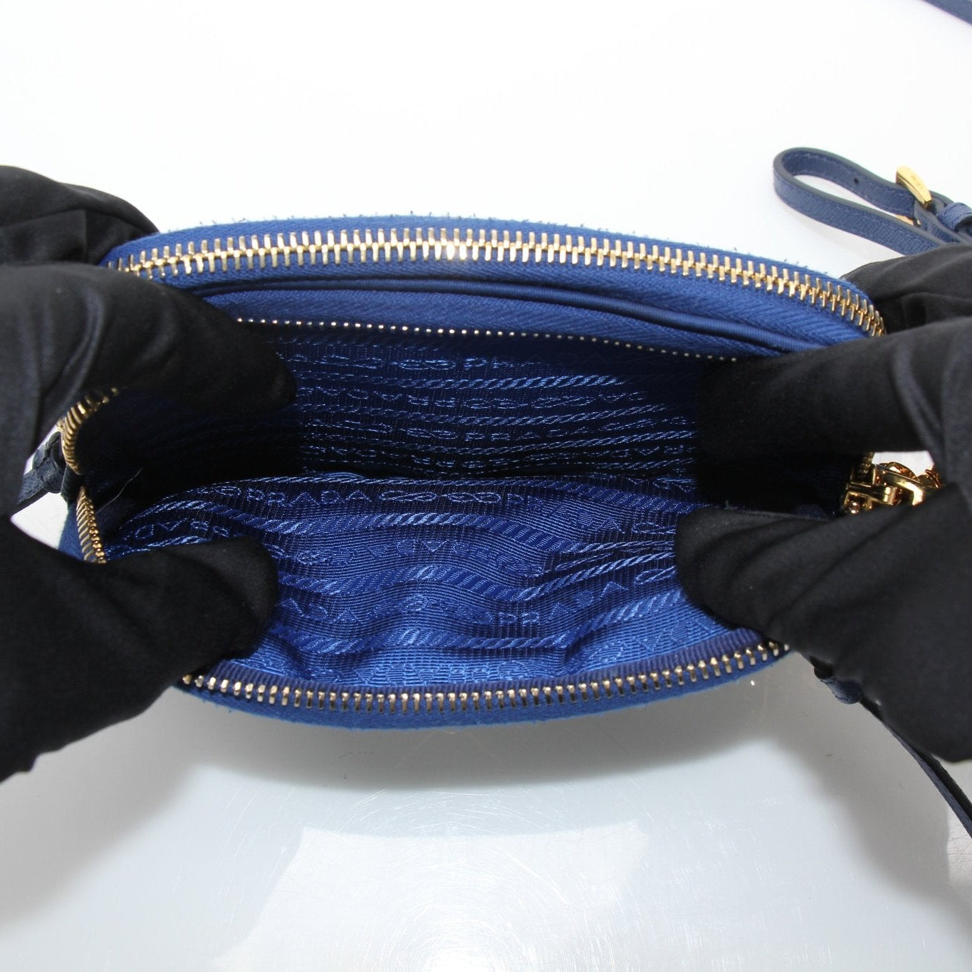 Blue nylon Prada crossbody handbag with gold accents, featuring a sleek design and adjustable strap.