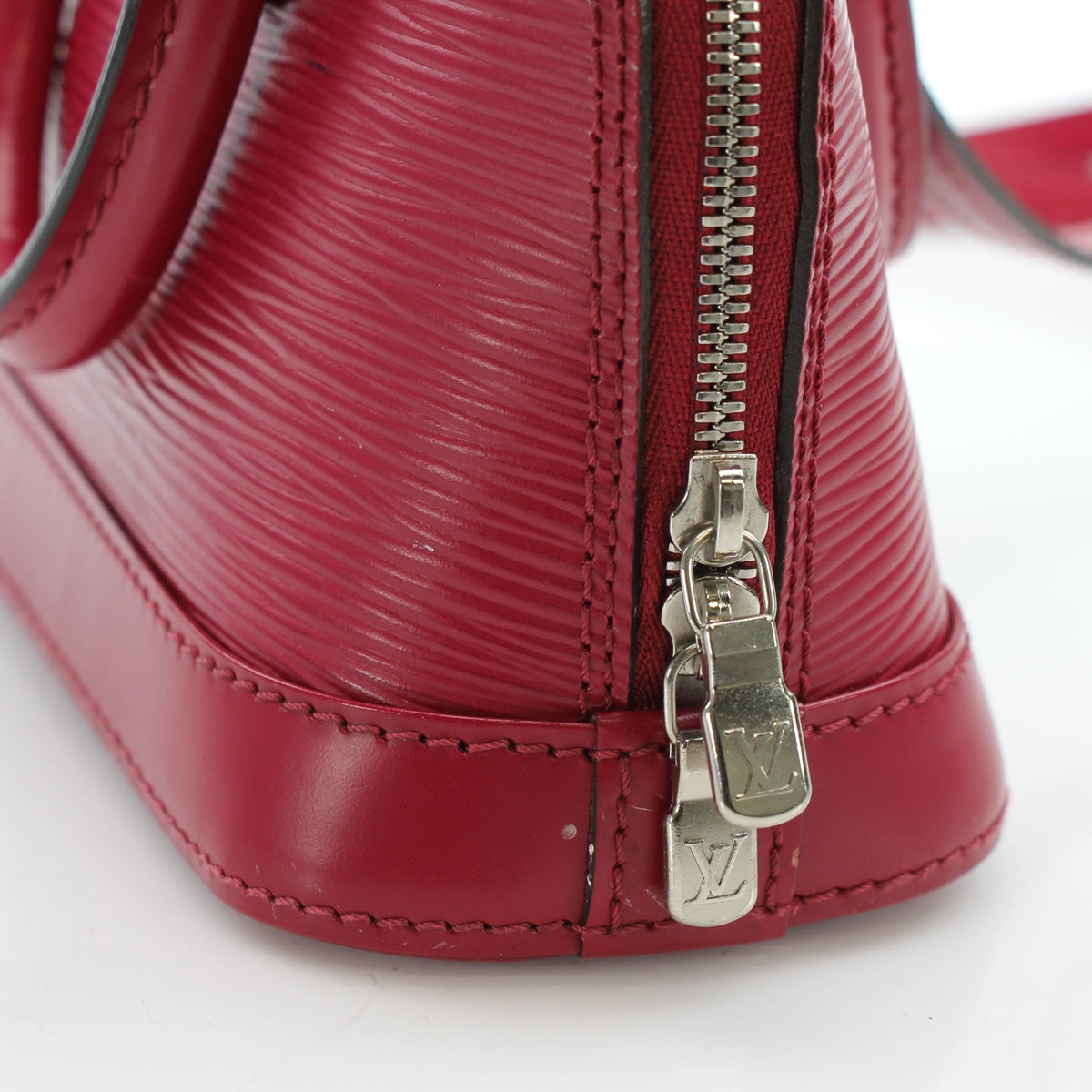 Louis Vuitton Epi Nano Alma handbag in red leather with gold hardware, featuring a compact and stylish design.
