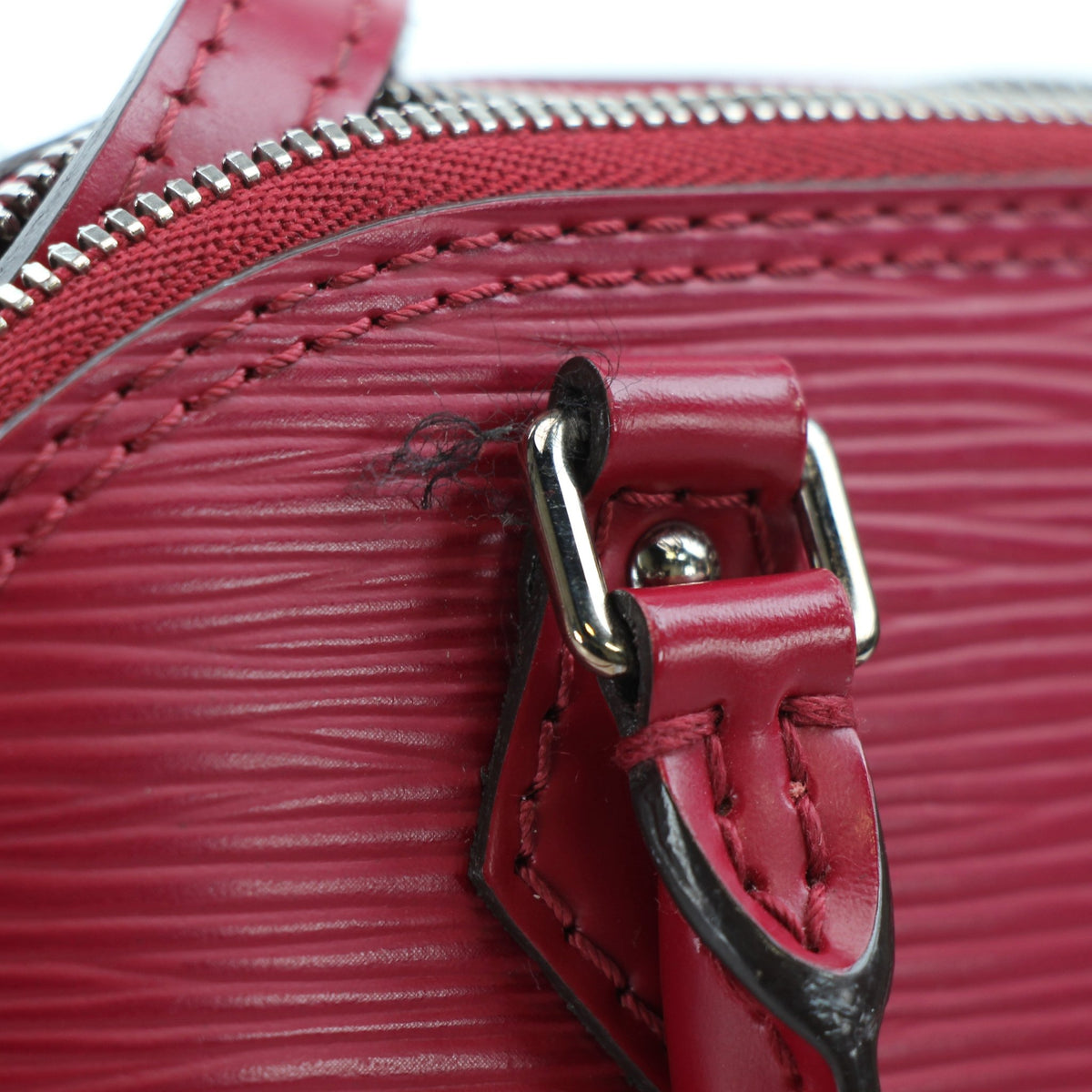 Louis Vuitton Epi Nano Alma handbag in red leather with gold hardware, featuring a compact, structured design and top handle.