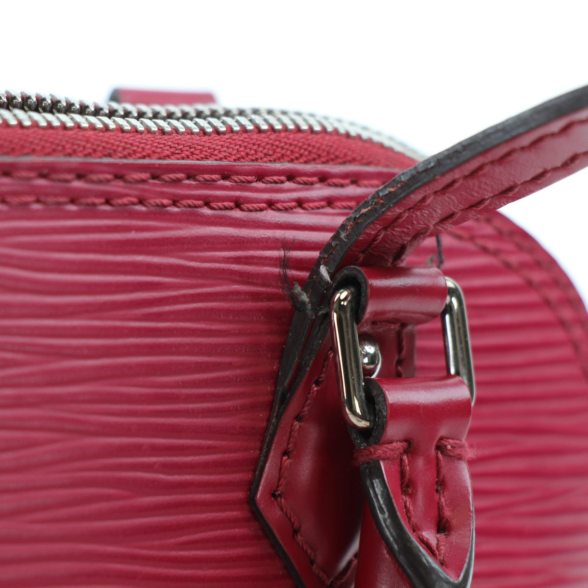 Louis Vuitton Epi Nano Alma red leather handbag with gold hardware, compact design, and signature structured silhouette.