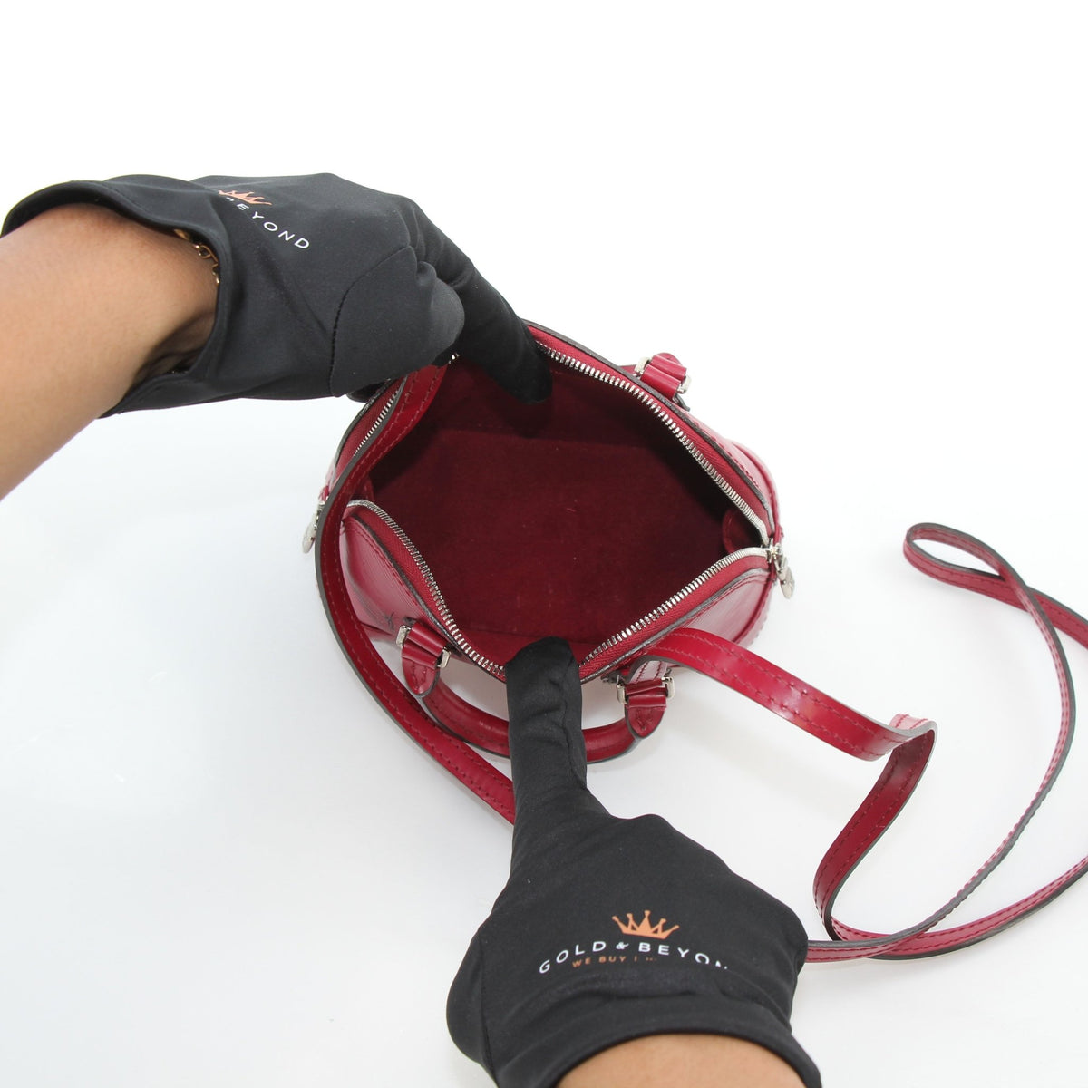 Louis Vuitton Epi Nano Alma red leather handbag with gold hardware and structured shape, displayed on a neutral background.