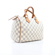 Louis Vuitton Damier Azur Speedy 25 handbag with leather handles and gold hardware, featuring the iconic checkered pattern.
