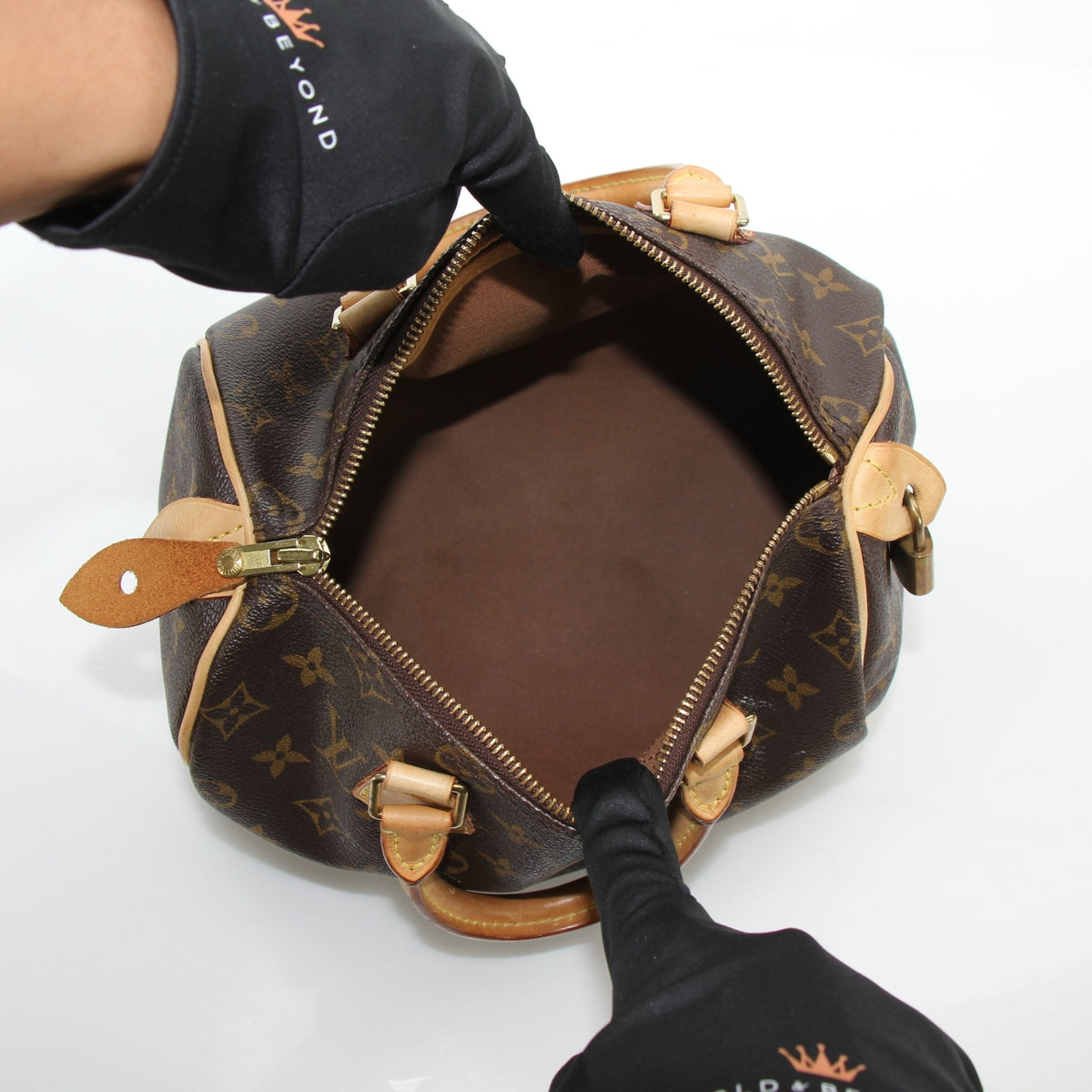 Louis Vuitton Monogram Speedy 25 handbag with leather handles and gold hardware, featuring the iconic monogram canvas.
