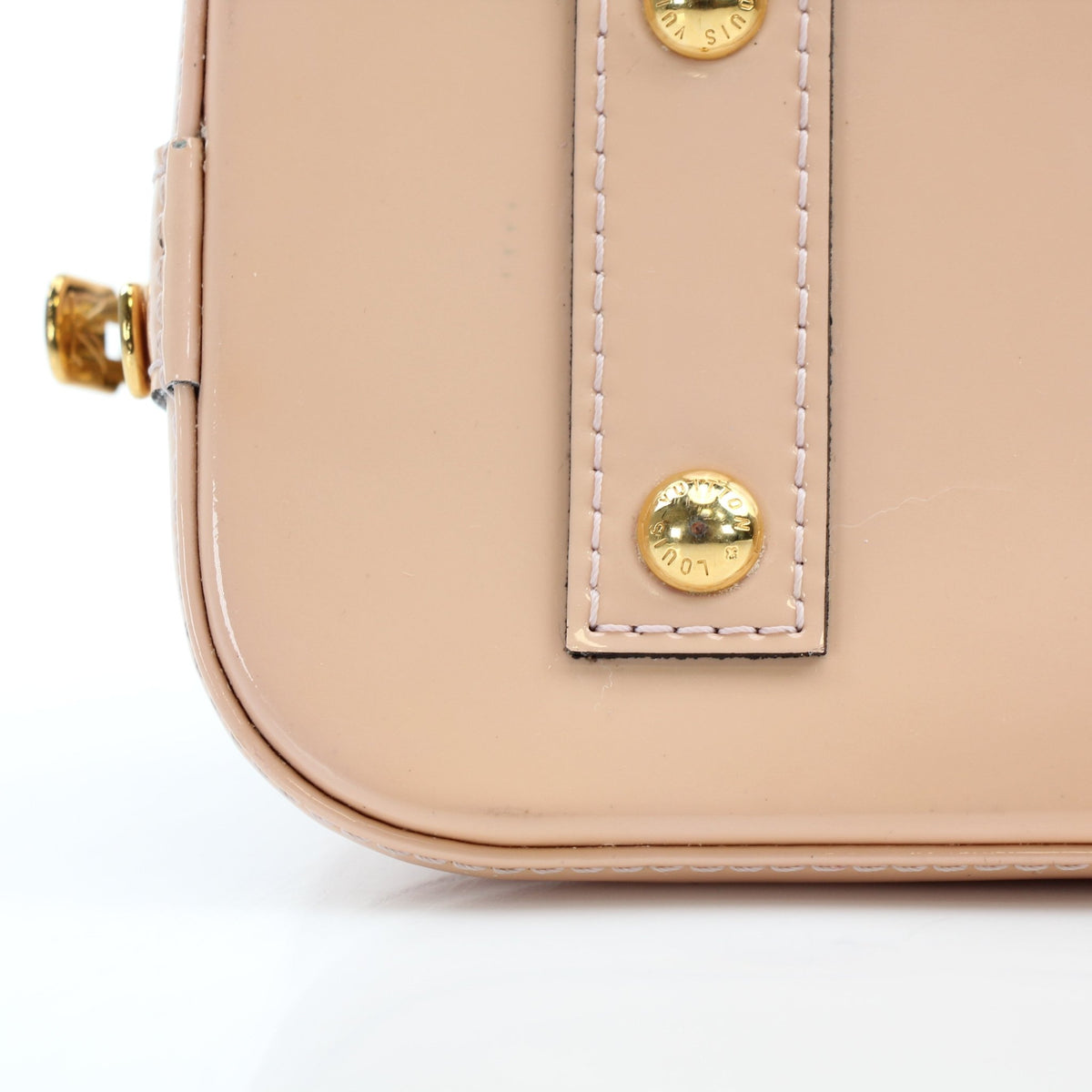 Blush pink Louis Vuitton Alma BB handbag with gold hardware and structured design, displayed on a neutral background.