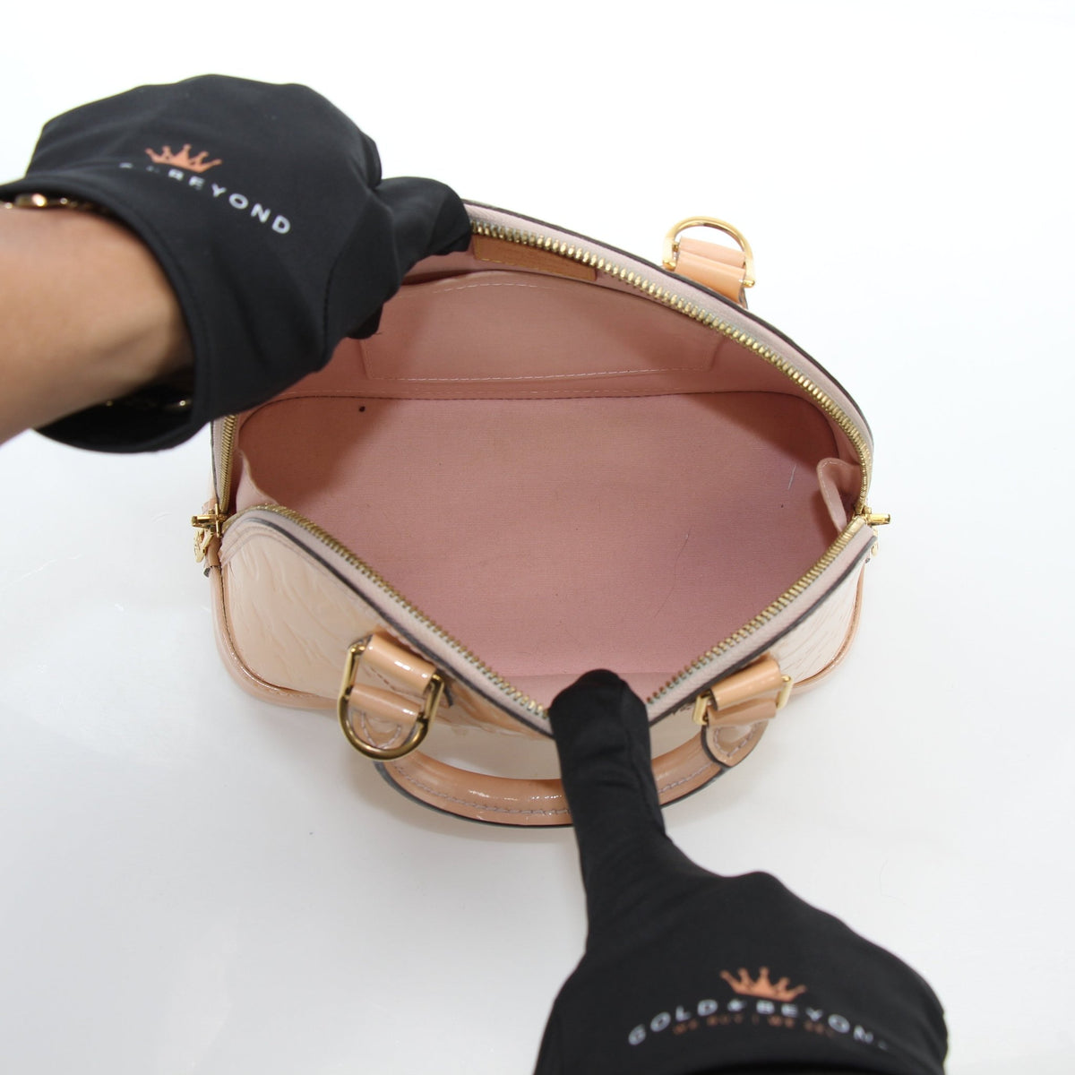 Louis Vuitton blush pink Alma BB handbag with gold hardware, featuring structured design and top handles.
