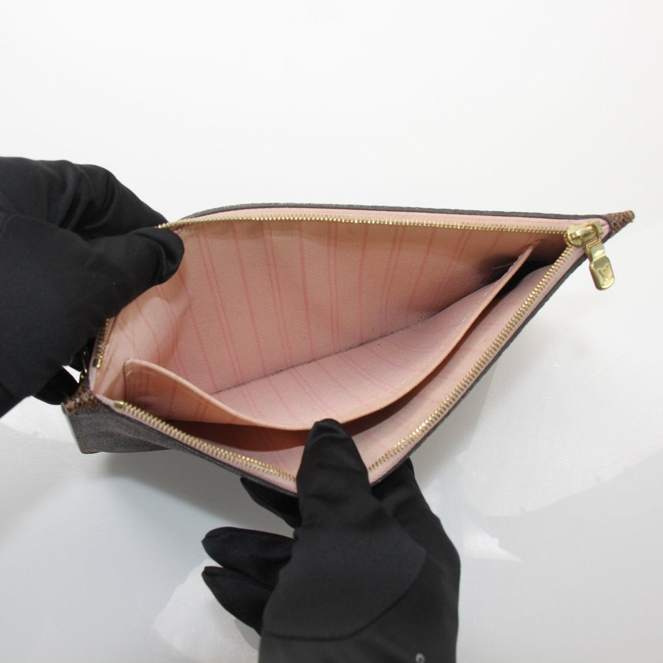 Gold & Beyond Louis Vuitton Pochette Wristlet, a stylish travel bag with gold accents and a wrist strap.