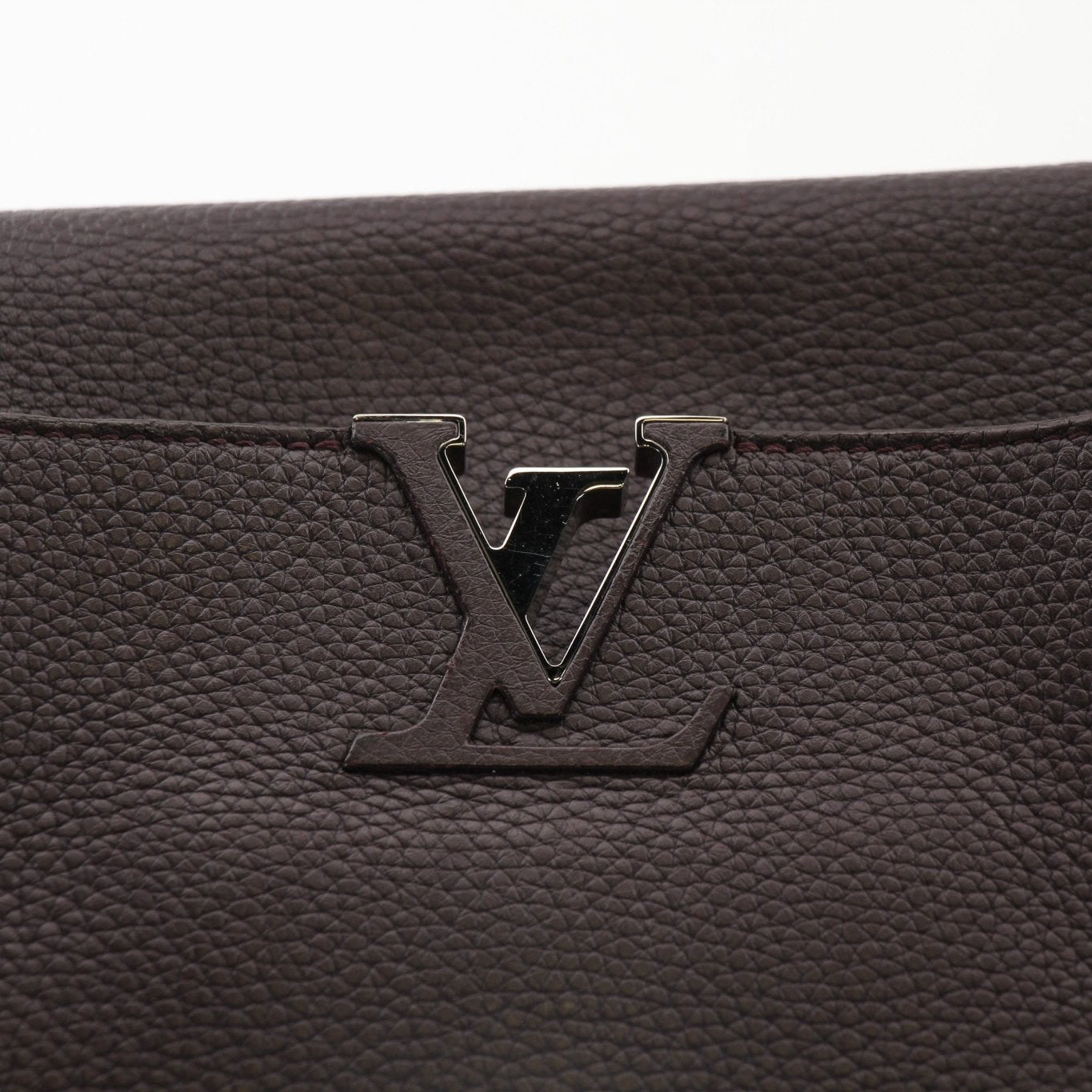 Louis Vuitton Capucines MM top handle handbag with leather and gold hardware, displayed with its elegant design and structured shape.