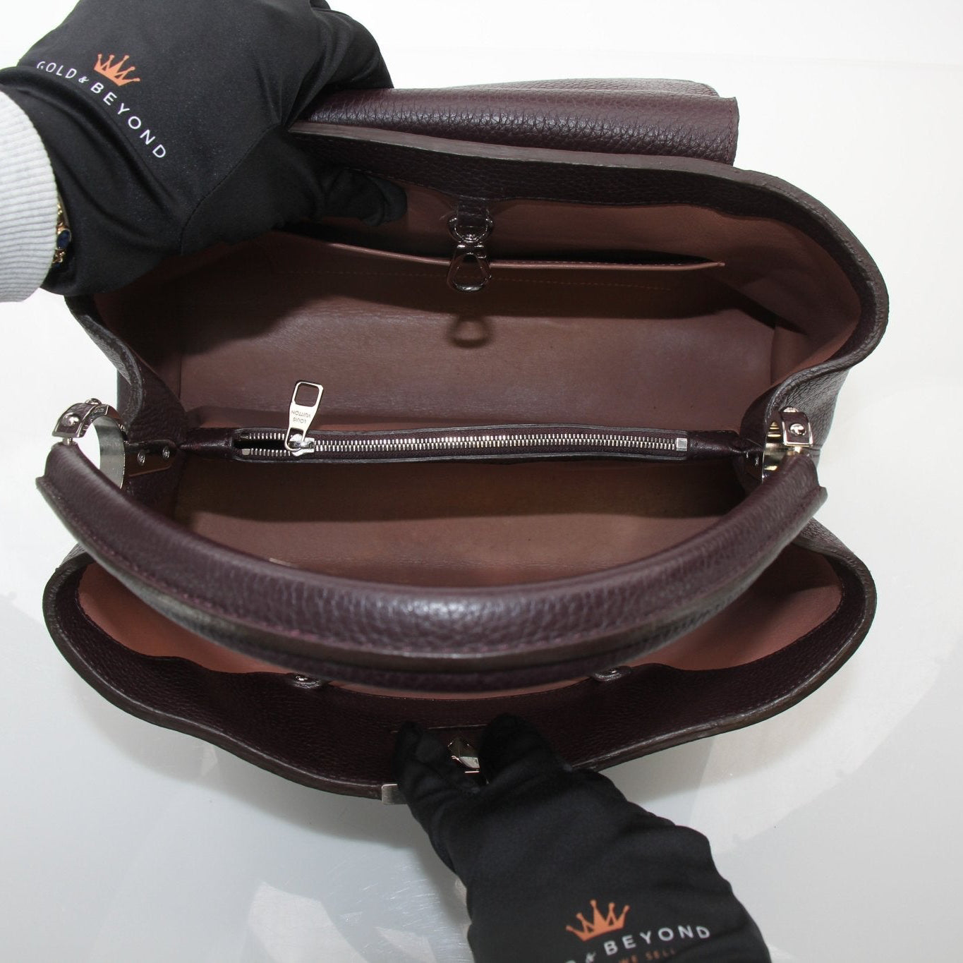 Louis Vuitton Capucines MM top handle handbag with leather exterior and gold-tone hardware, displayed on a neutral background.