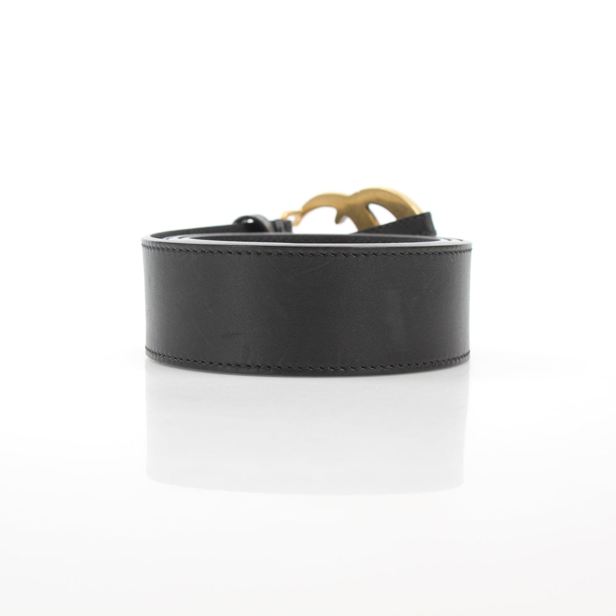Black Gucci GG Marmont wide leather belt with gold-toned buckle, featuring the signature GG logo embossed on the leather.