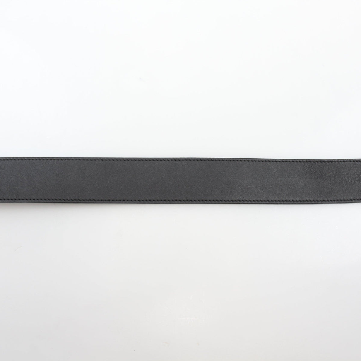 Black Gucci GG Marmont wide leather belt with gold buckle, stylish accessory laid flat on a white background.