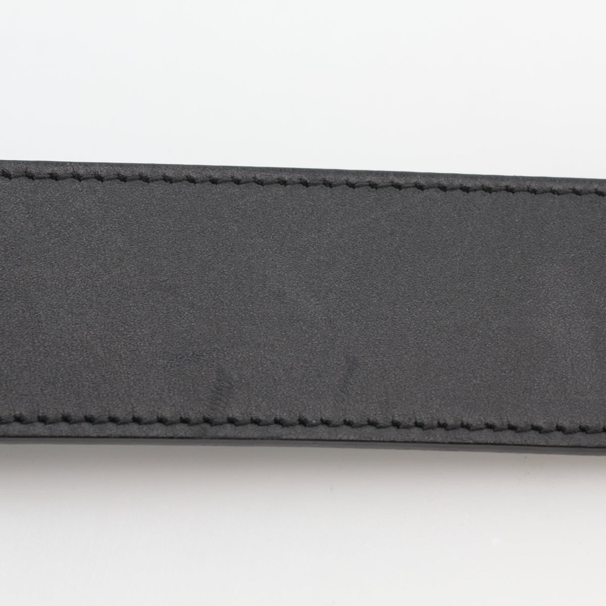 Black leather Gucci GG Marmont wide belt with gold hardware, styled as an accessory on a neutral background.