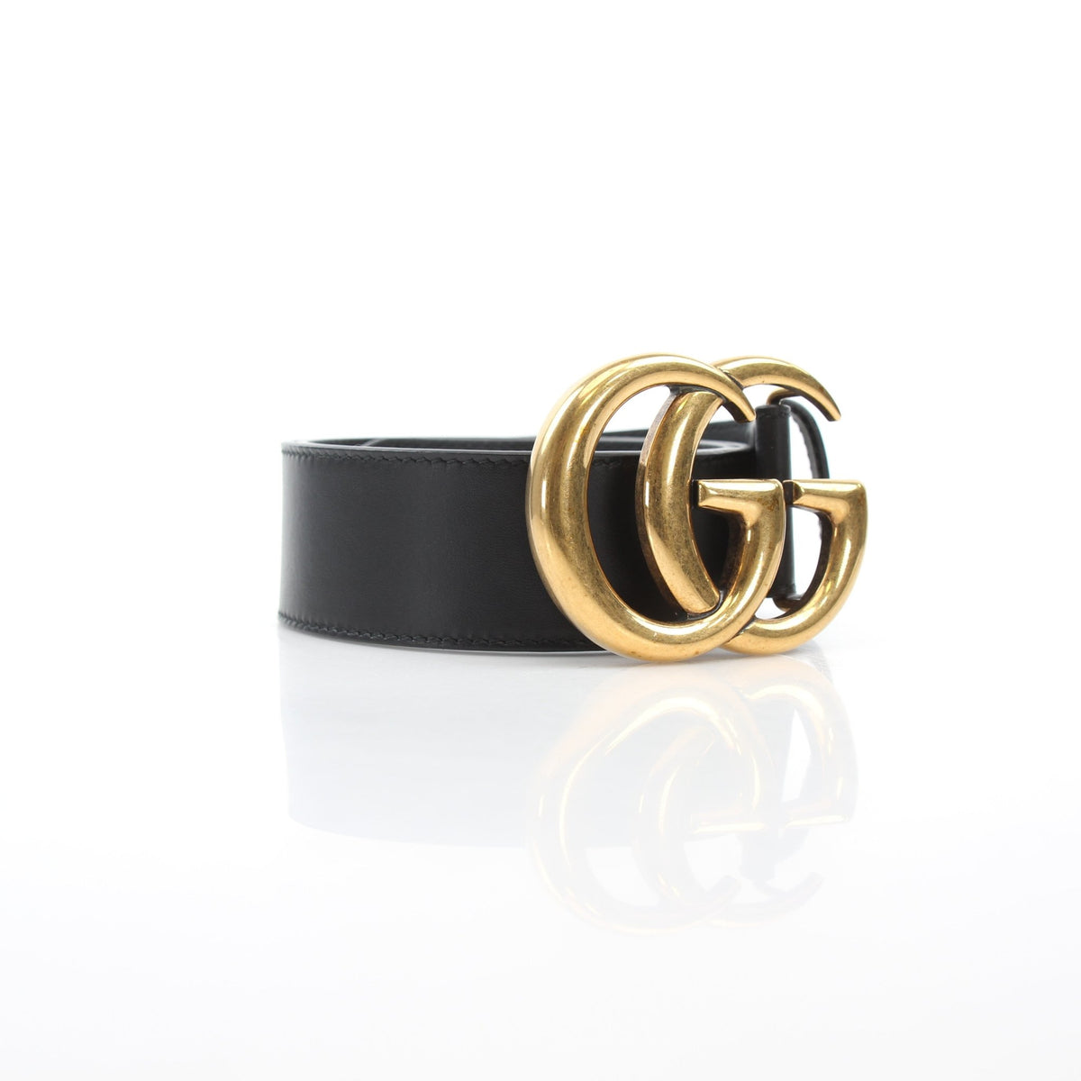 Black leather Gucci GG Marmont wide belt with gold hardware, featuring double G logo buckle and textured finish.
