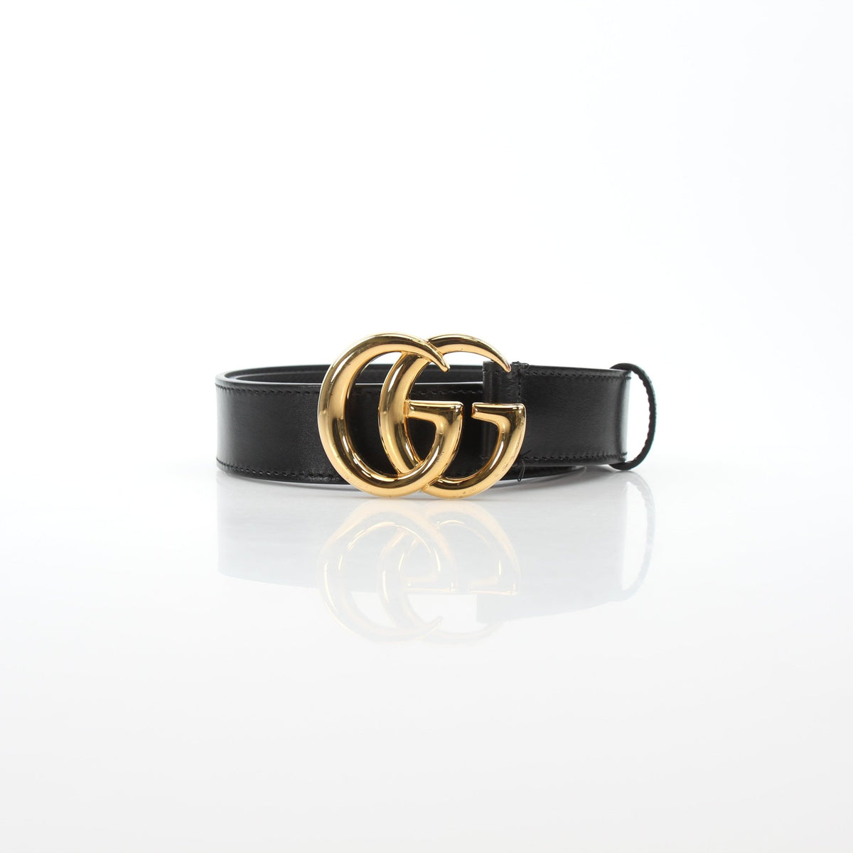 Black Gucci GG Marmont thin leather belt with gold hardware, stylish accessory displayed on a neutral background.
