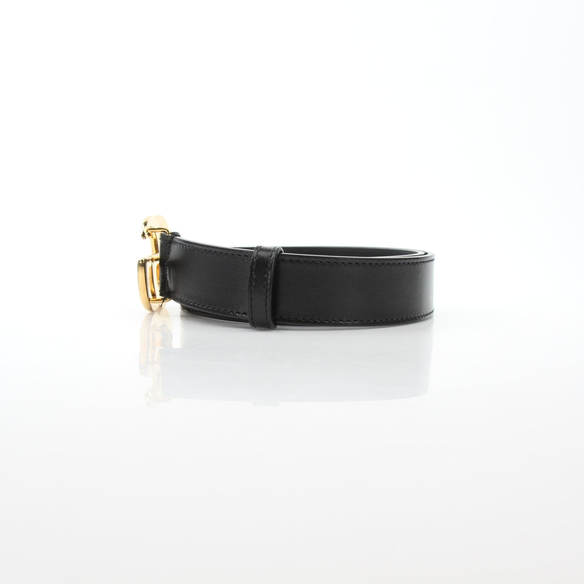 Black leather Gucci GG Marmont thin belt, stylish accessories with gold hardware, showcased on a plain background.
