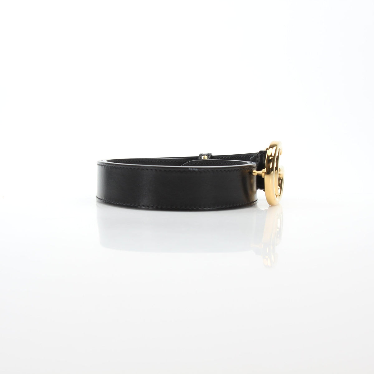 Black Gucci GG Marmont thin leather belt with gold-tone hardware, stylish accessory displayed on a neutral background.