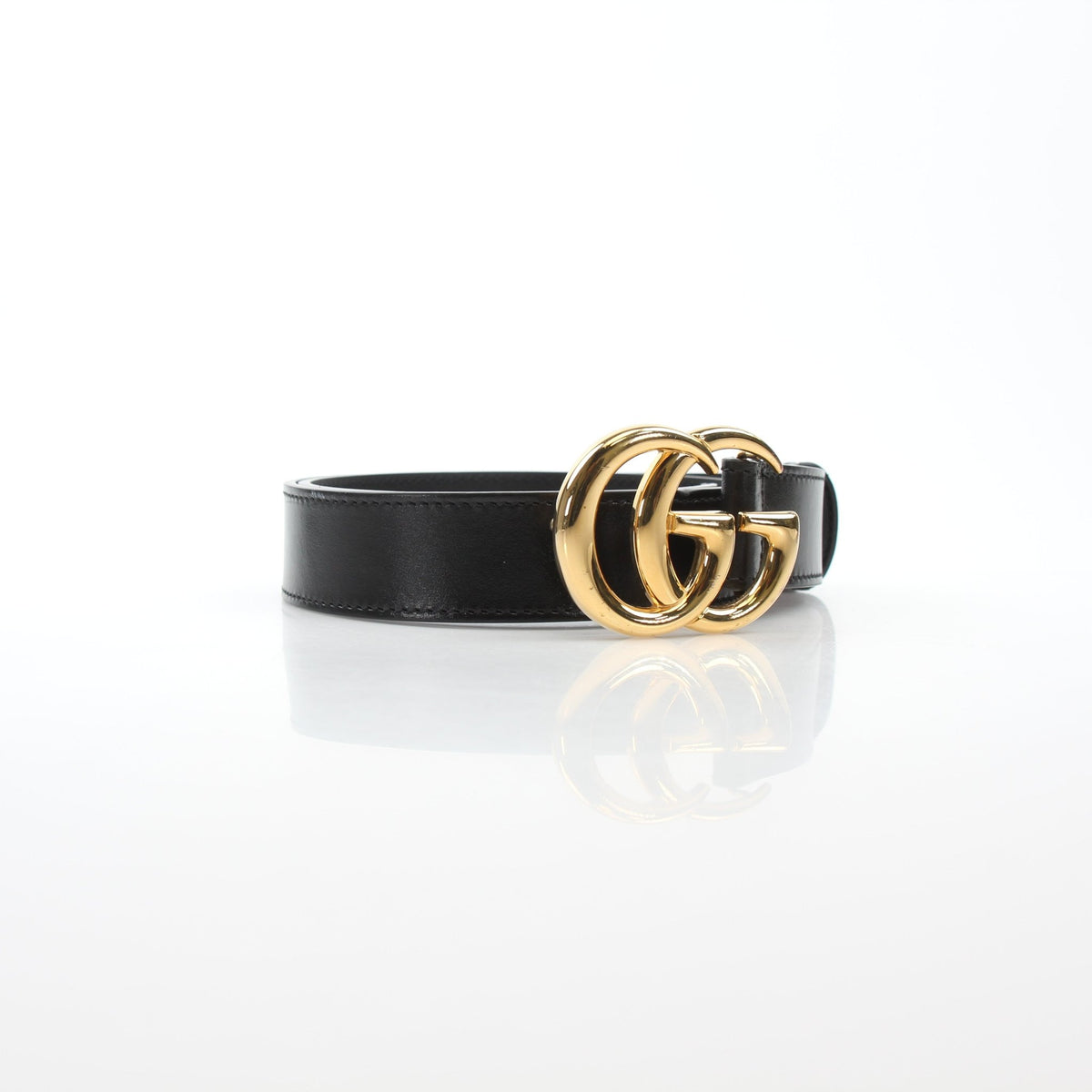 Black Gucci GG Marmont thin leather belt with gold-tone hardware, shown on a neutral background.