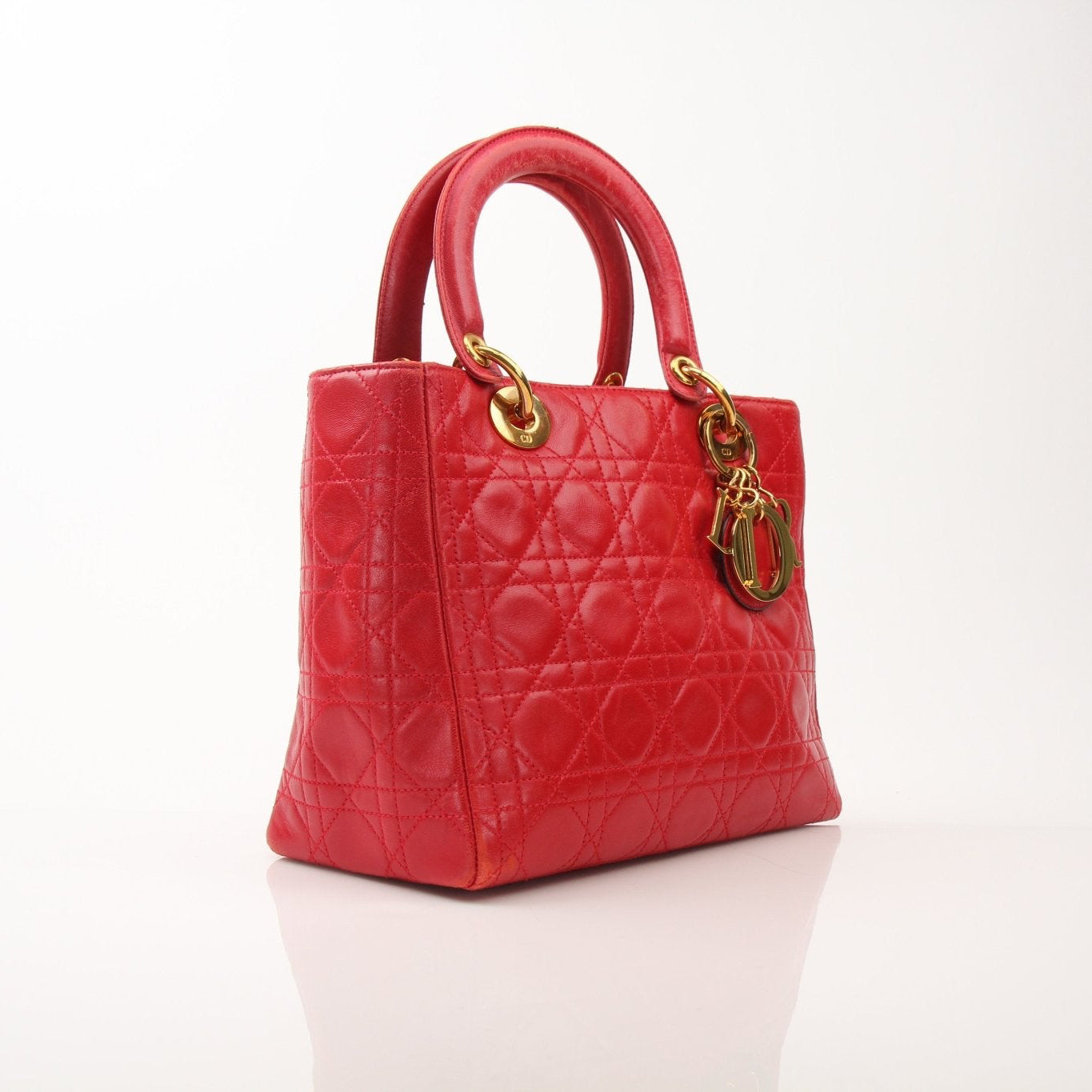 Red Lady Dior handbag with top handle in smooth leather, featuring gold hardware and signature Dior logo details.