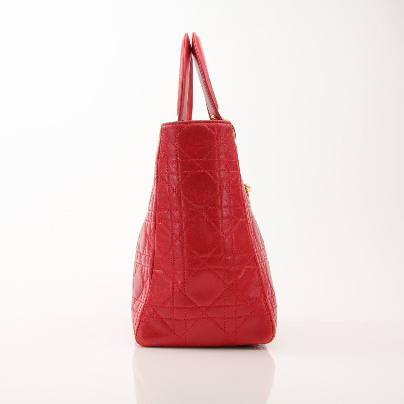 Red Lady Dior handbag with top handle and gold accents, featuring classic design and luxury craftsmanship from Christian Dior.