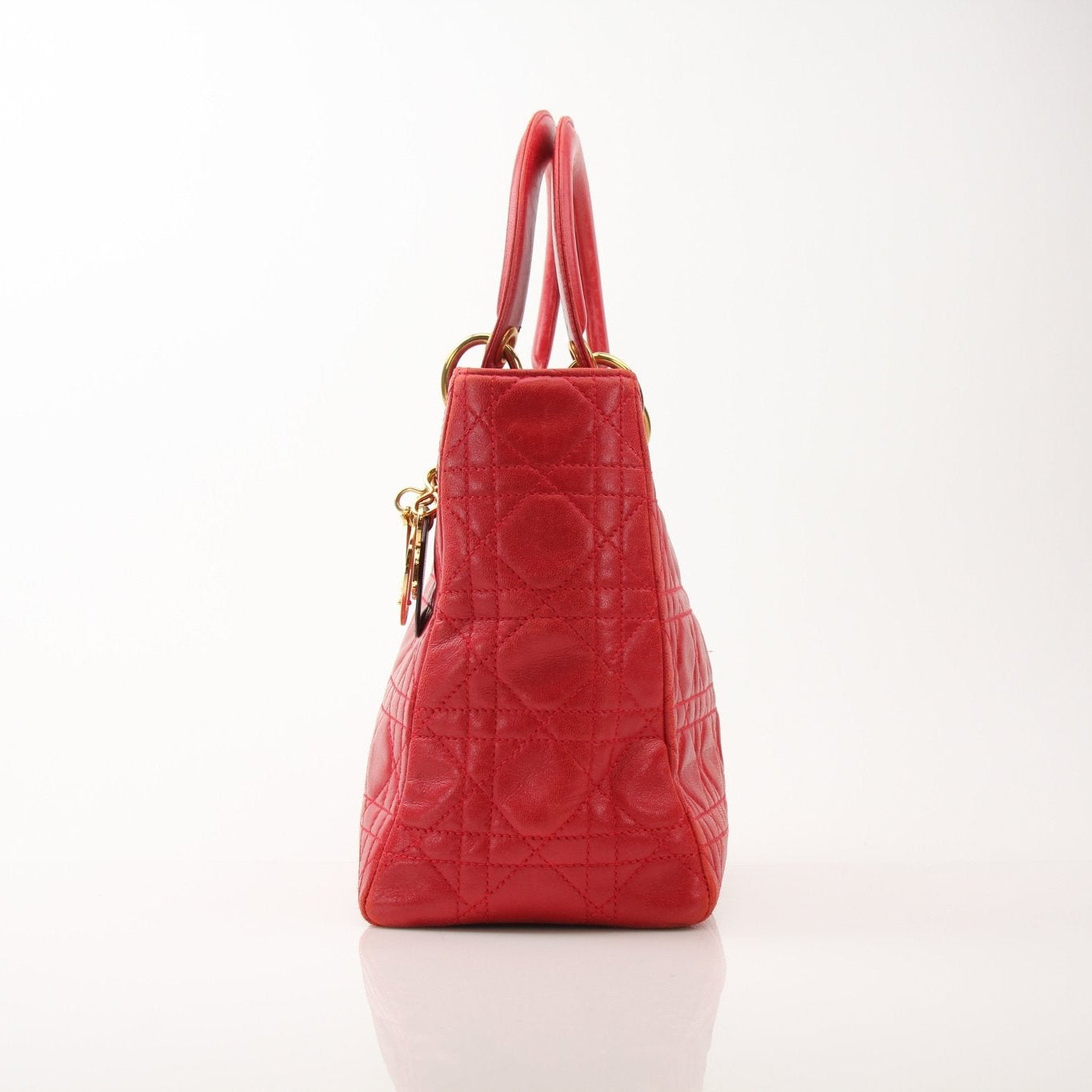 Red Christian Dior Lady Dior handbag with top handle and gold accents, showcased by Gold & Beyond.
