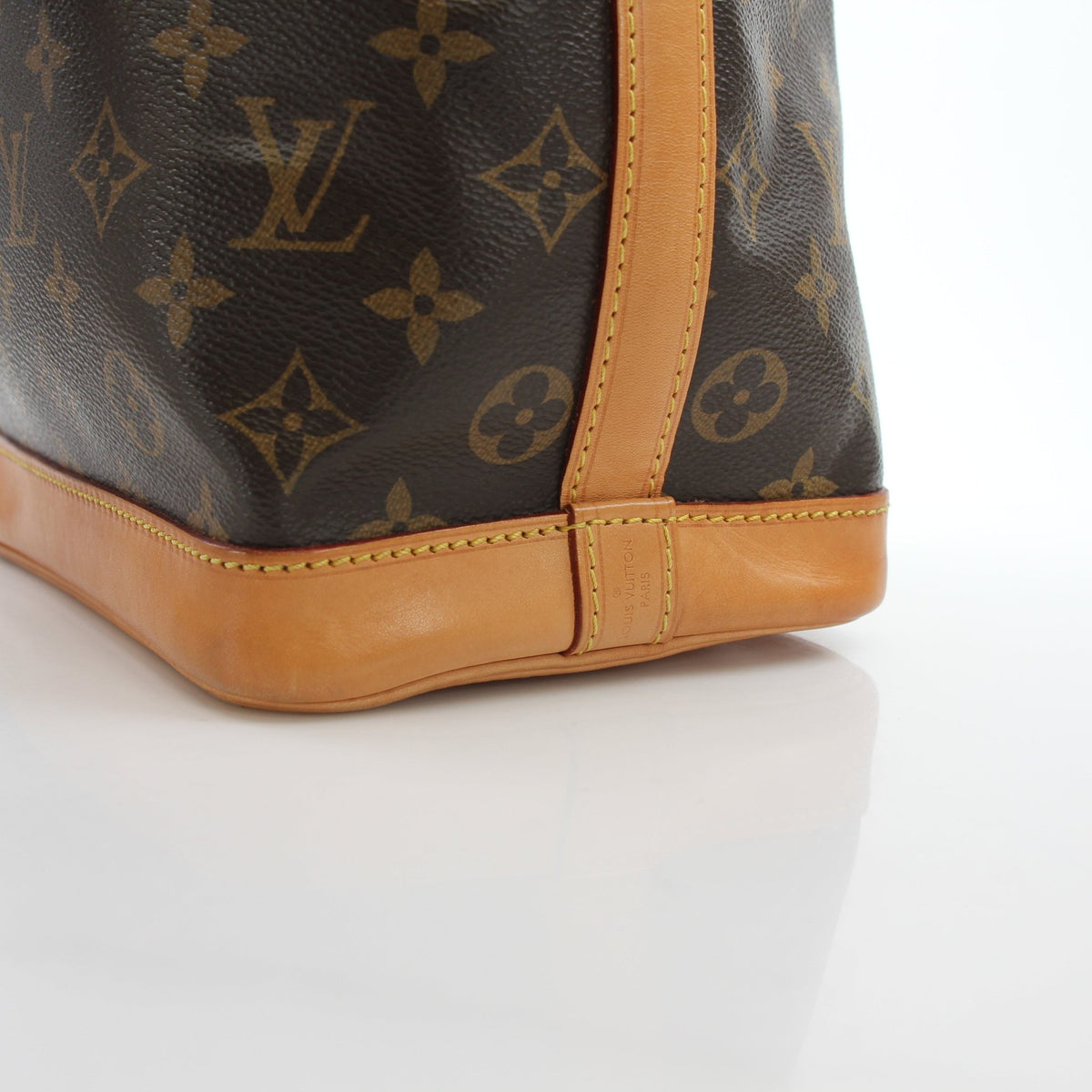 Louis Vuitton Noé BB Monogram bucket handbag with gold-tone hardware and adjustable leather strap, displayed on a neutral background.