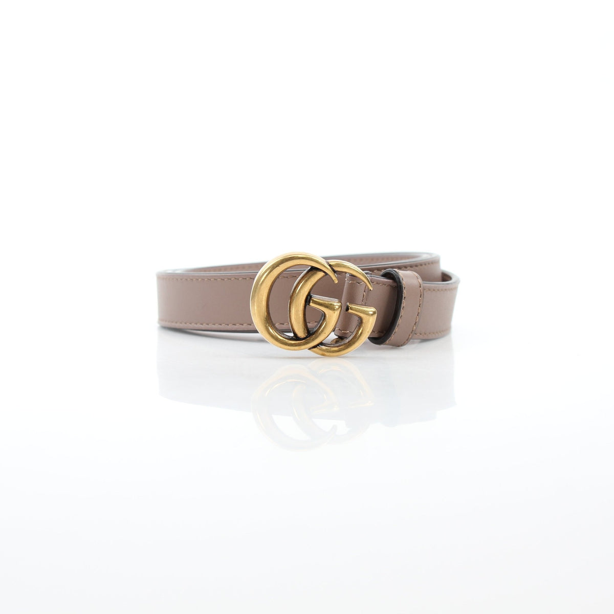 Gucci GG Marmont thin leather belt in taupe with gold hardware, styled as a sleek accessory on a neutral background.