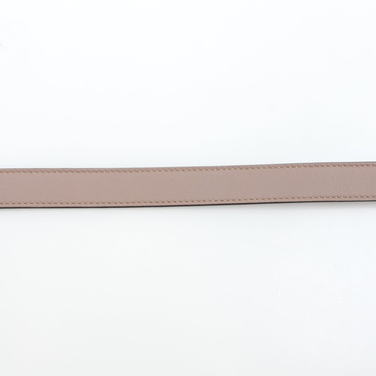 Gucci GG Marmont thin leather belt in taupe with gold hardware, showcased as a stylish accessory.