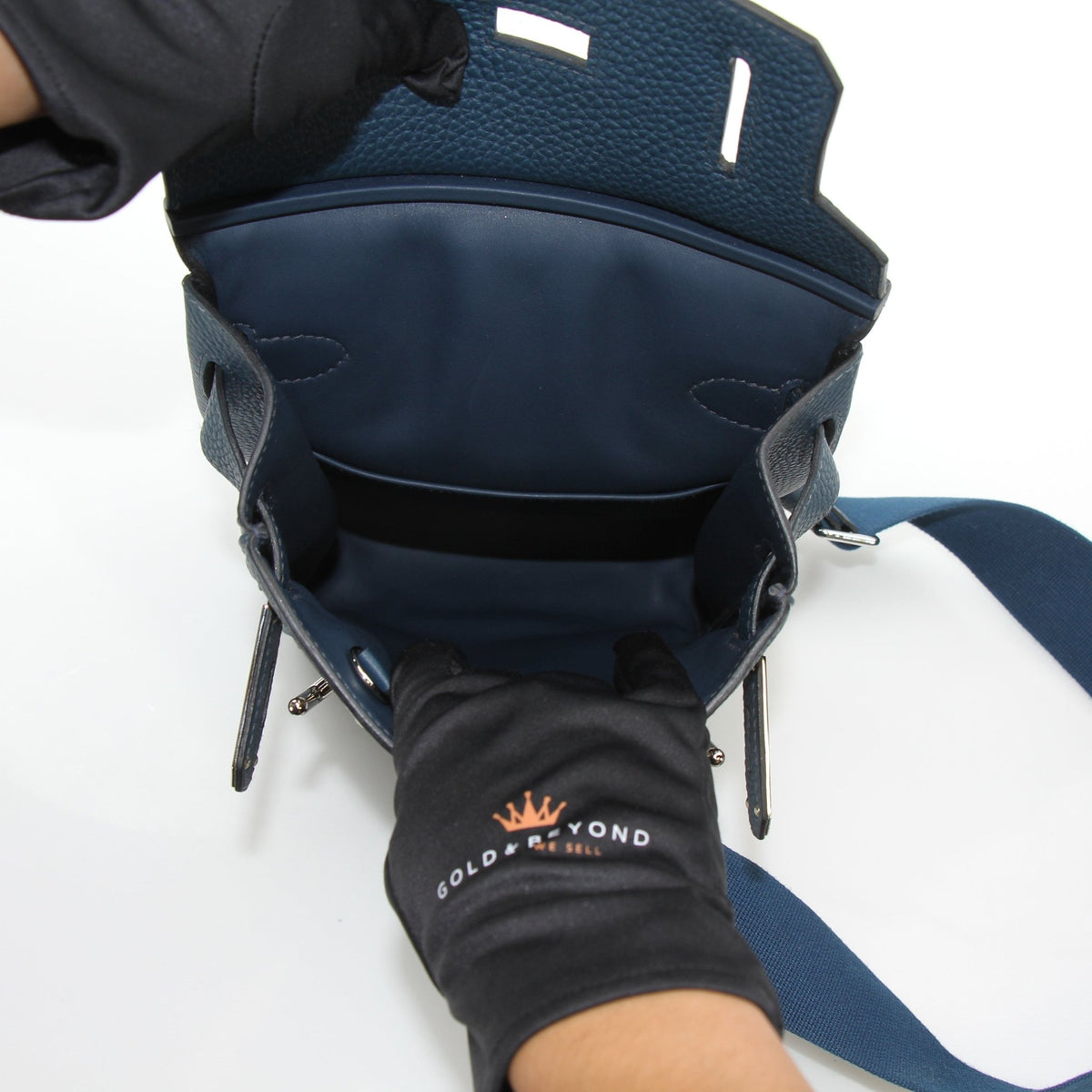 Dark blue Hermès Hac a Dos PM Togo calfskin backpack with adjustable straps and gold hardware, displayed on a neutral background.