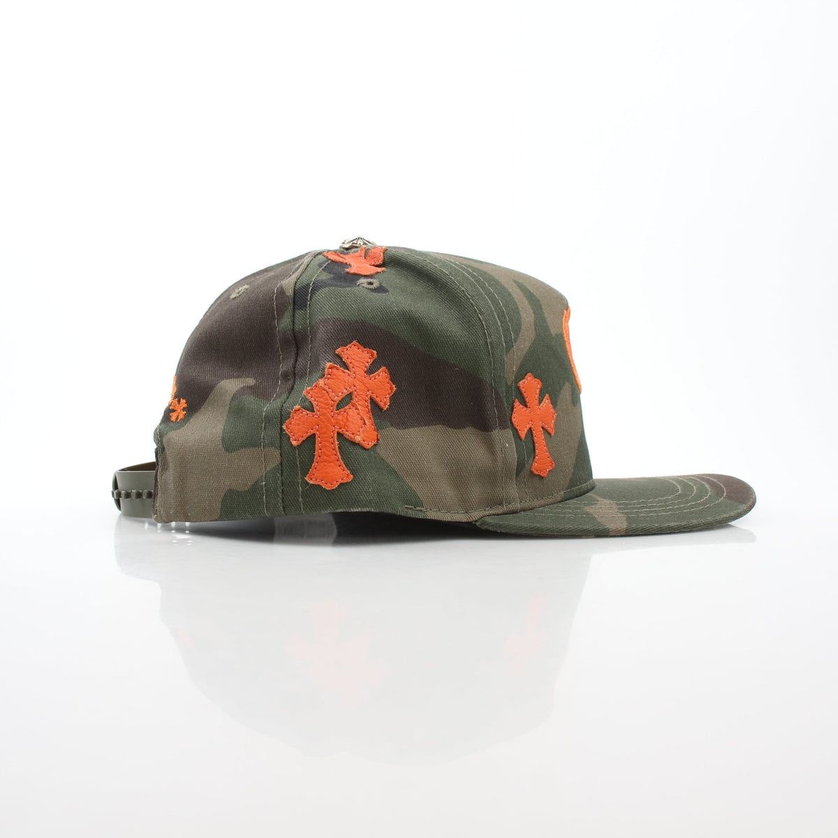 Chrome Hearts Camo Orange Cemetery Cross patch on Gold & Beyond baseball hat, showing camouflage fabric and embroidered cross detail.