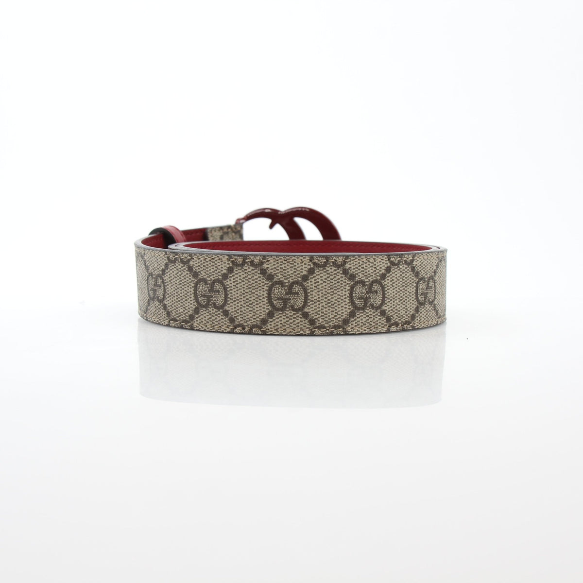 Gucci Double G belt in beige ebony and cherry red leather, featuring gold hardware, displayed on a plain background.