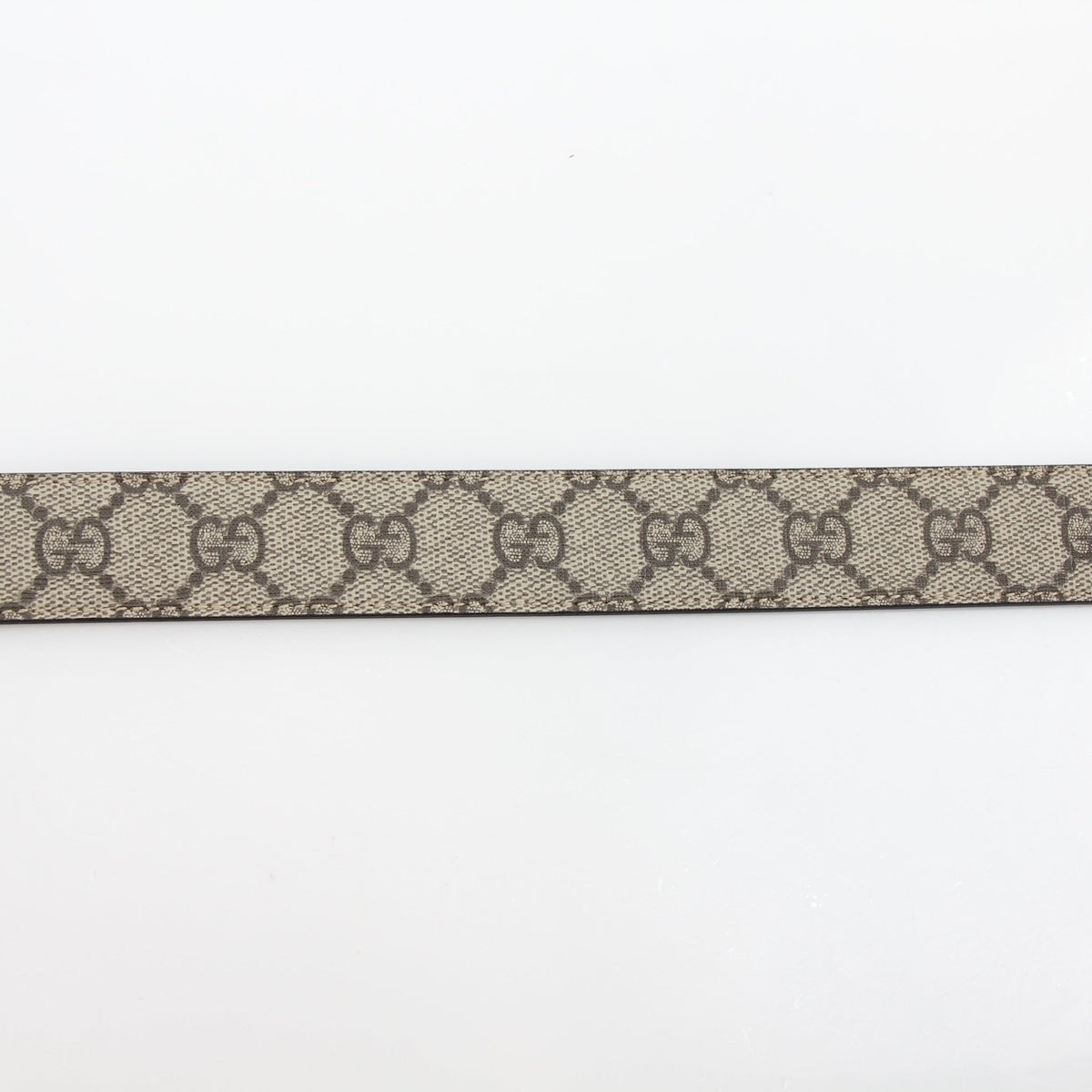 Gucci Double G belt in beige and ebony with cherry red accents, showcasing the designer leather accessories on a neutral background.