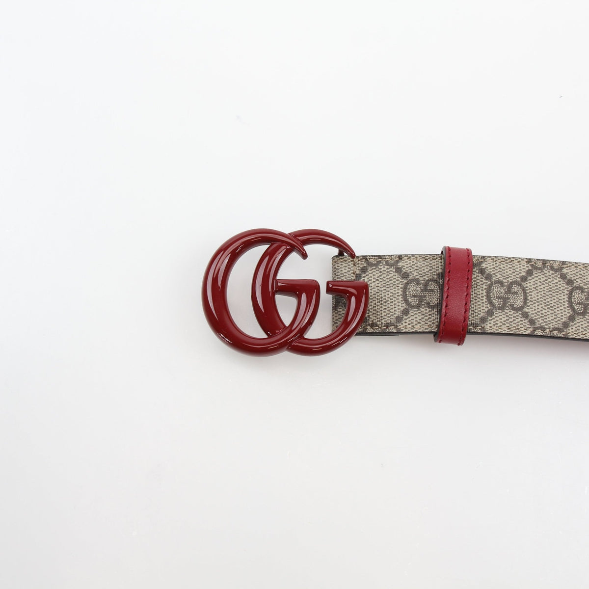 Gucci Double G belt in beige, ebony, and cherry red leather, stylish accessories with gold accents, displayed on a plain background.
