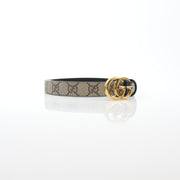 Reversible Gucci GG Supreme Marmont belt with beige and black leather, featuring gold-tone hardware and signature design.