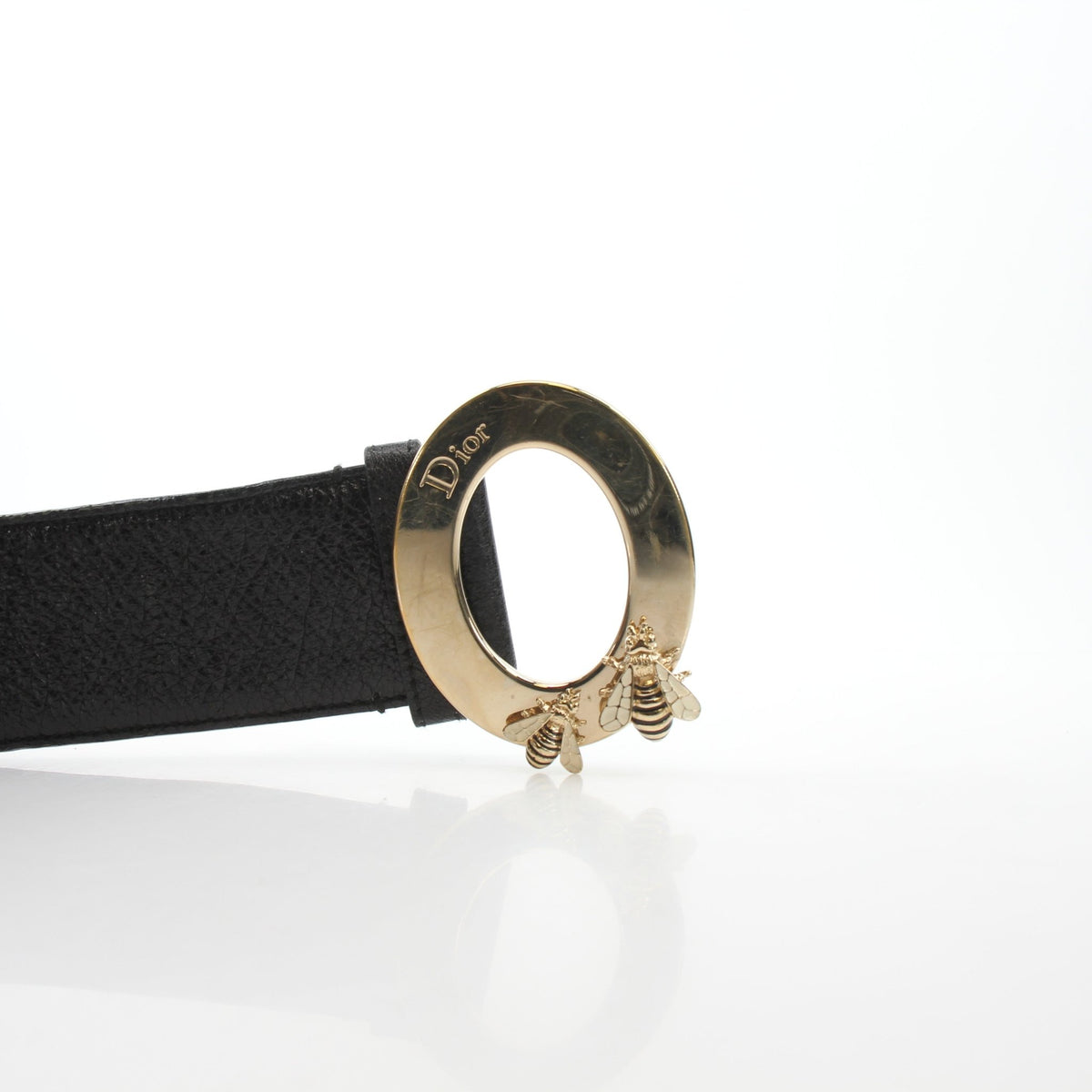 Black grained calfskin leather Christian Dior Cause Bee oval buckle belt with gold hardware and detailed craftsmanship.