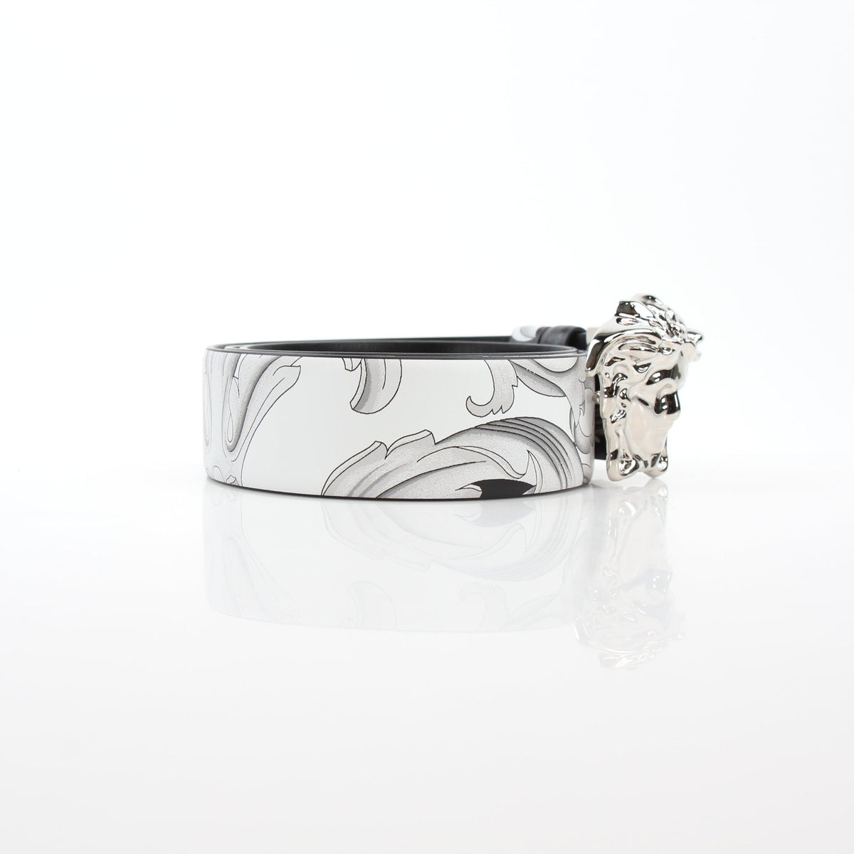 Versace men's reversible belt with Medusa Barocco design in black and white calfskin leather, styled as a luxury accessories piece.