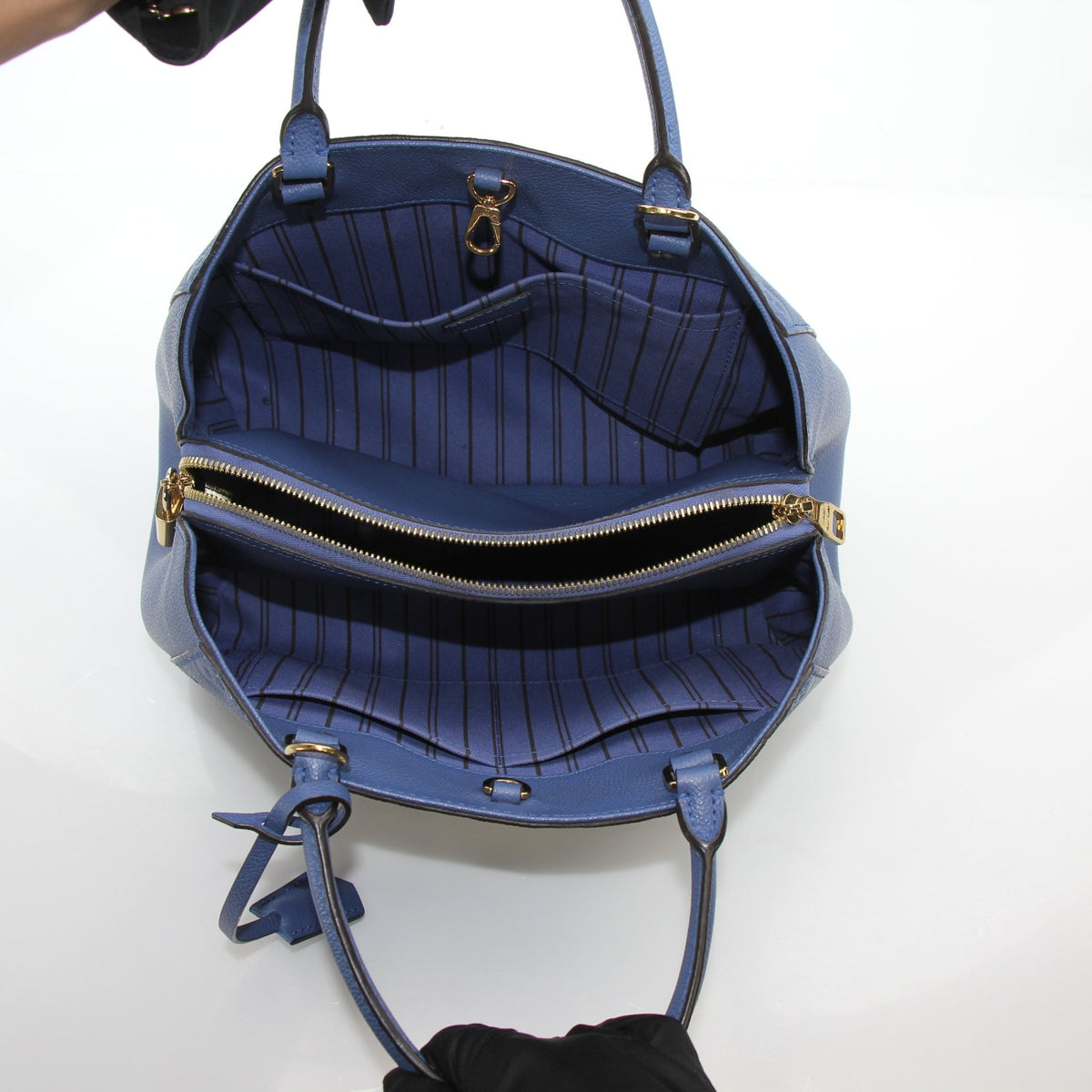 Louis Vuitton Montaigne MM Monogram Empreinte leather handbag in blue with gold hardware, featuring structured design and top handles.